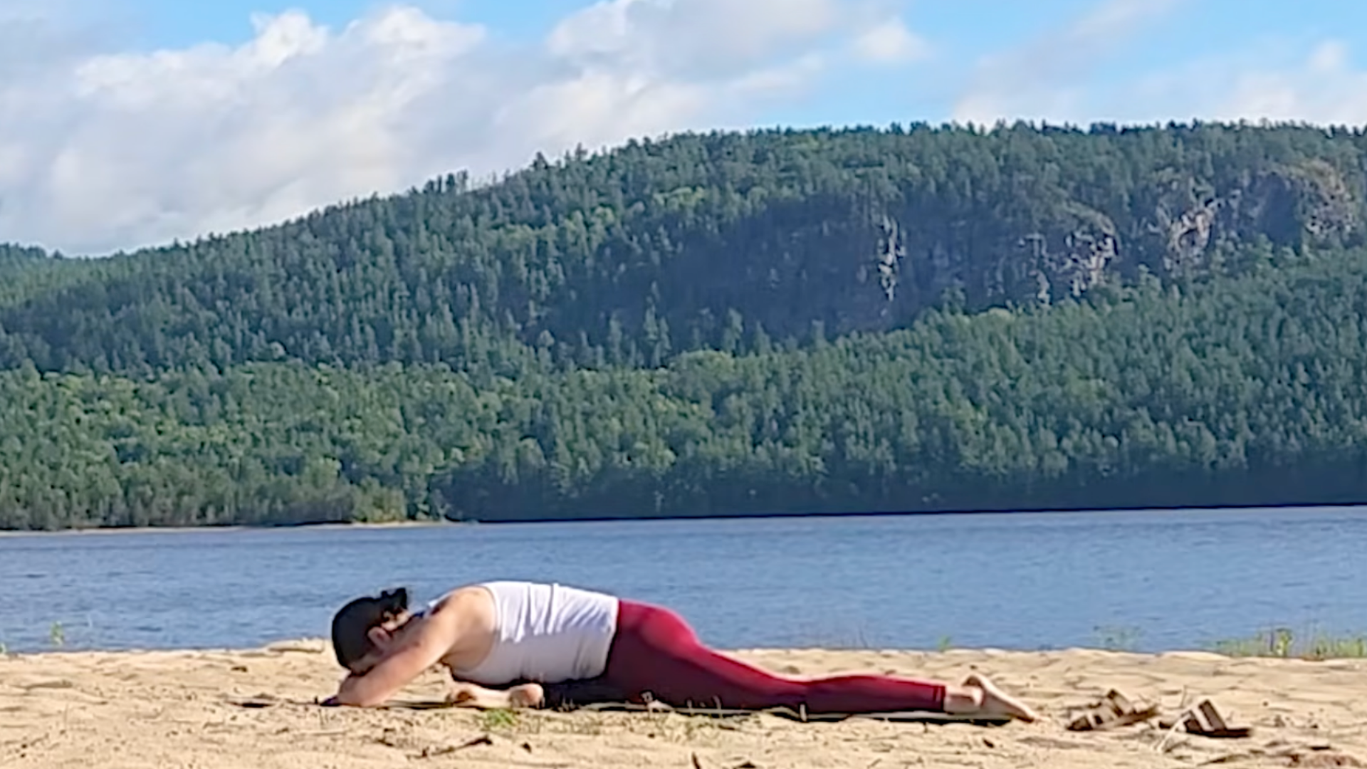 Woman lying on her front side in Pigeon Pose (Eka Pada Rajakapotasana)