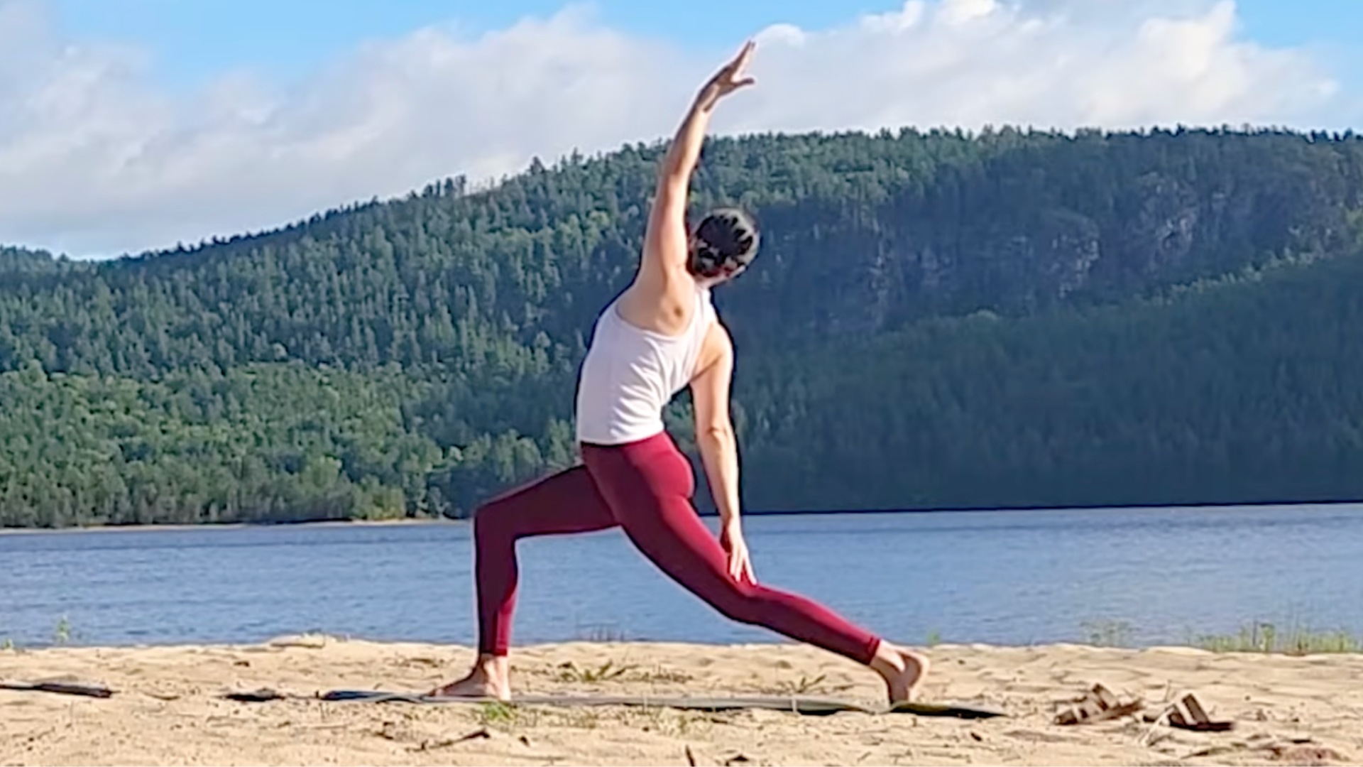 Woman practicing Exalted Warrior, a version of Reverse Warrior or Viparita Virabhadrasana with her lower arm on her back thigh, during a 15-minute yoga for back routine