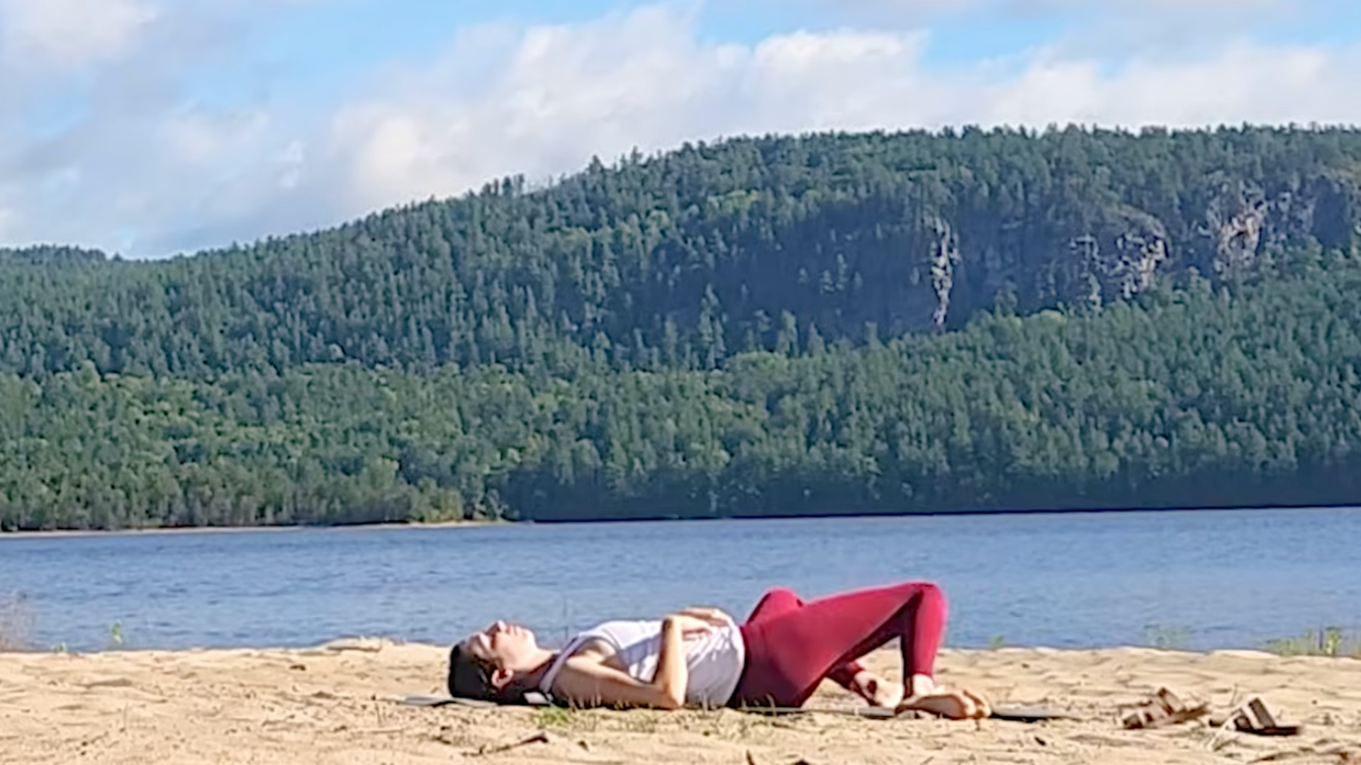 Woman lying on her back rocking her knees from side to side