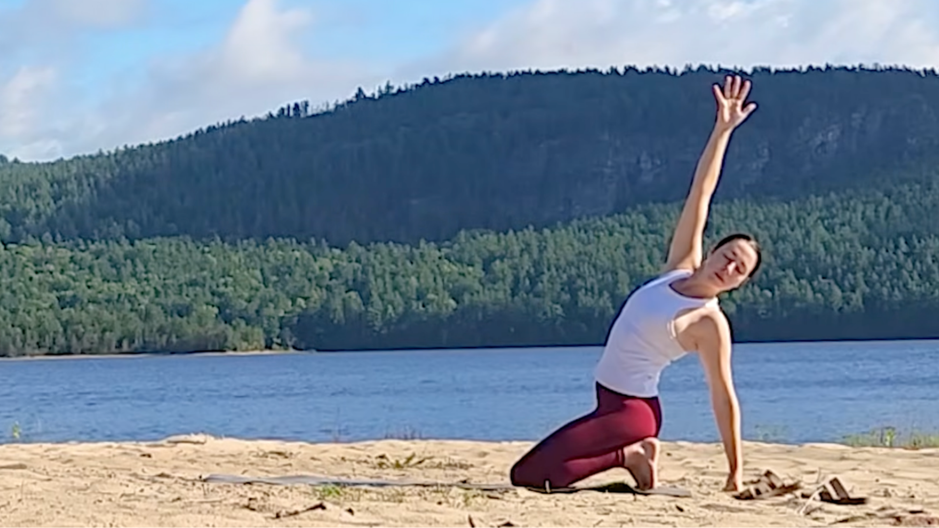 Woman kneeling with her toes tucked and her left arm on the mat behind her