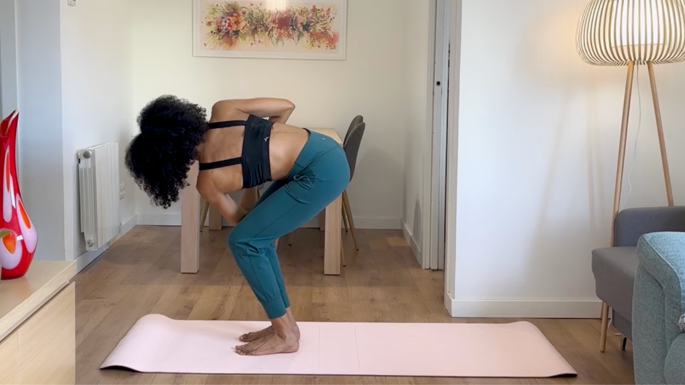 Yoga teacher practicing Revolved Chair Pose.