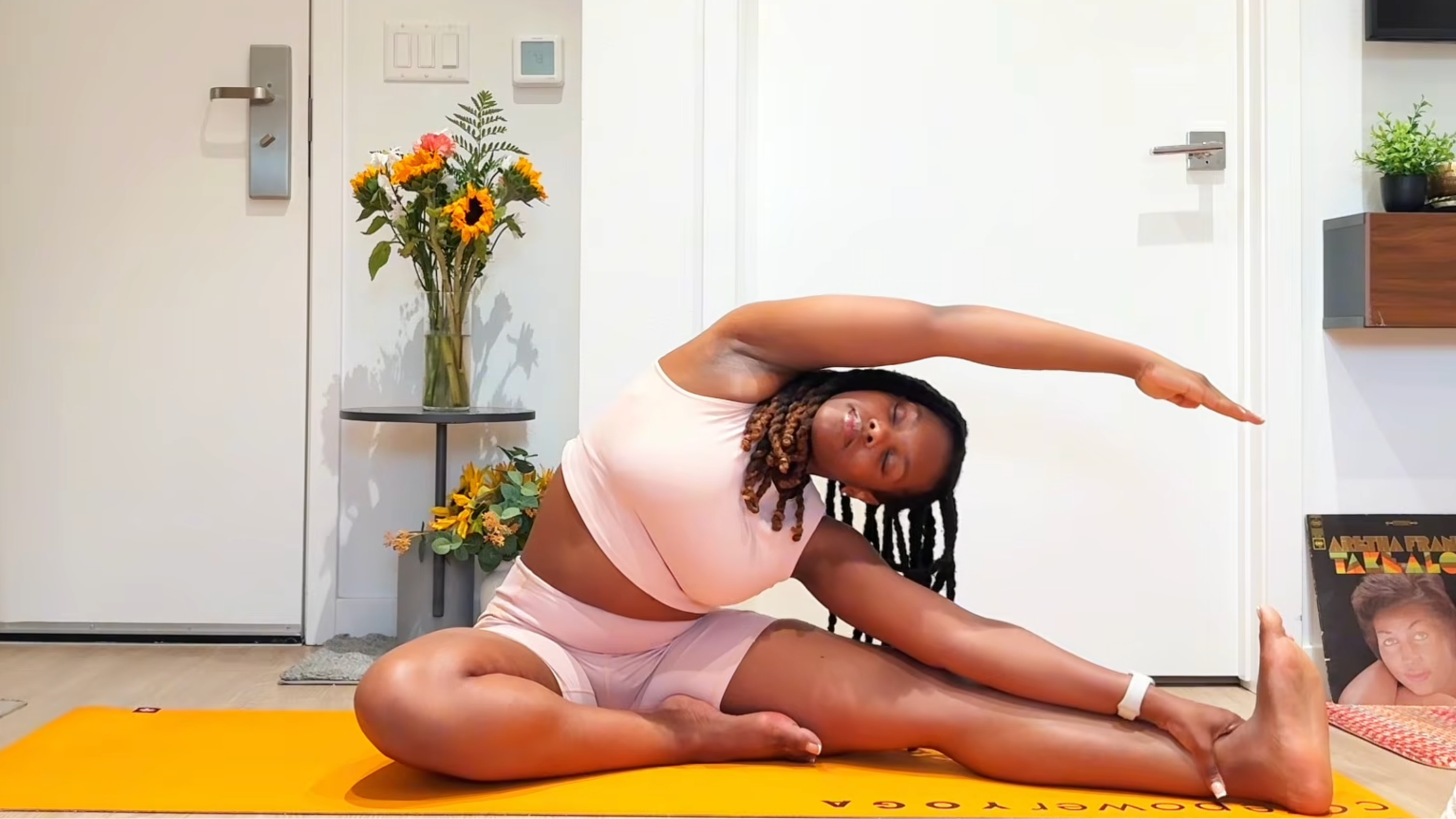 Yoga teacher practicing Revolved Head to Knee Pose.