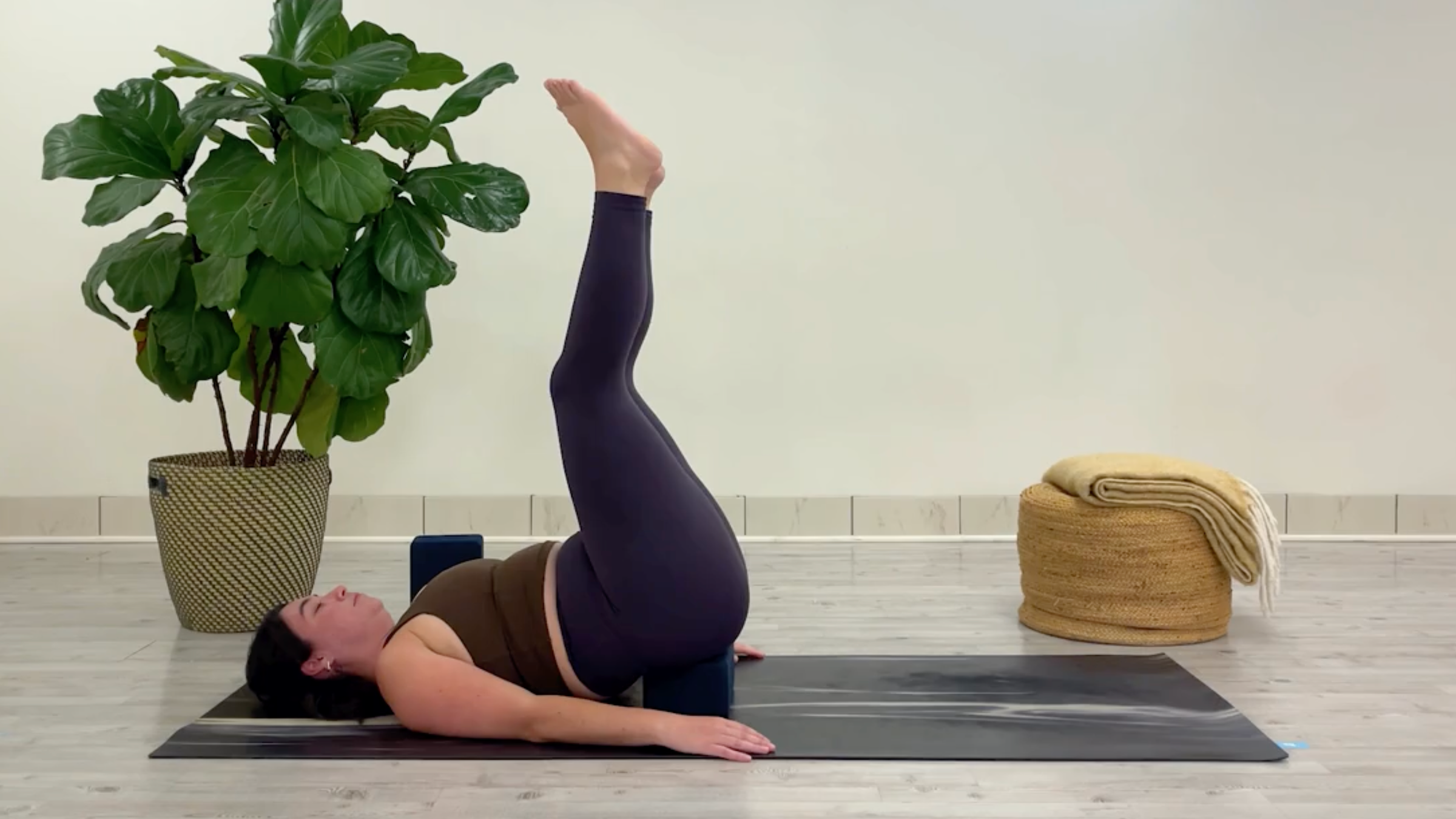 Yoga teacher Taylor Lorenz in Waterfall Pose, one of the best yoga poses for chilling out