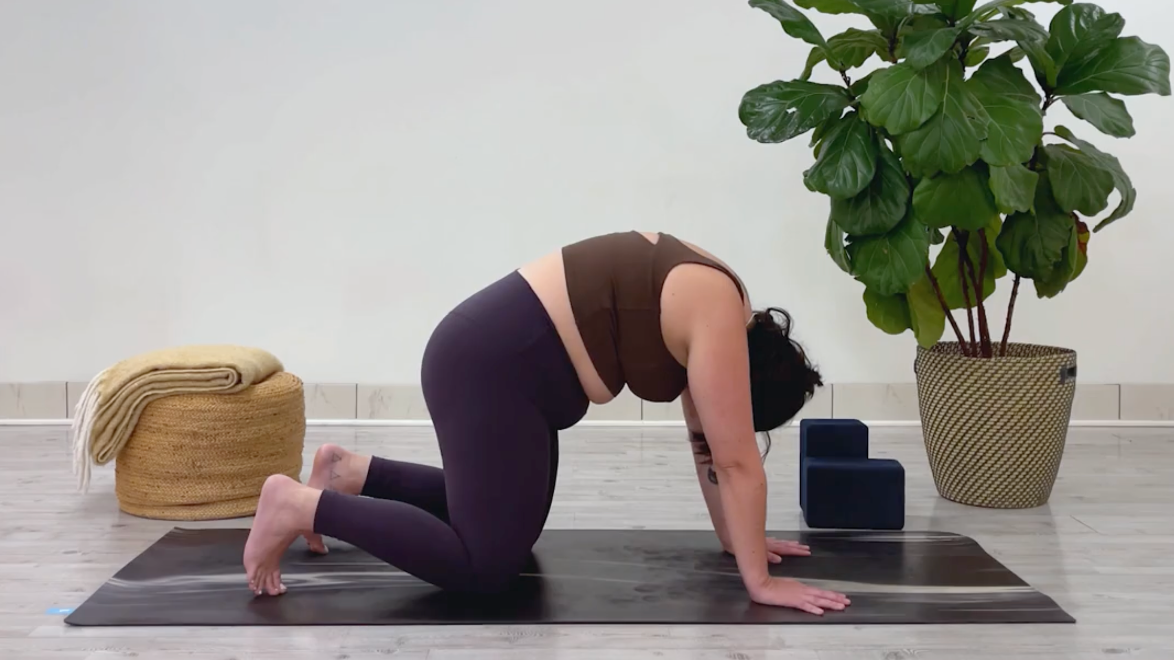 Yoga teacher Taylor Lorenz in Cat Pose, part of her 10-minute cool down yoga routine