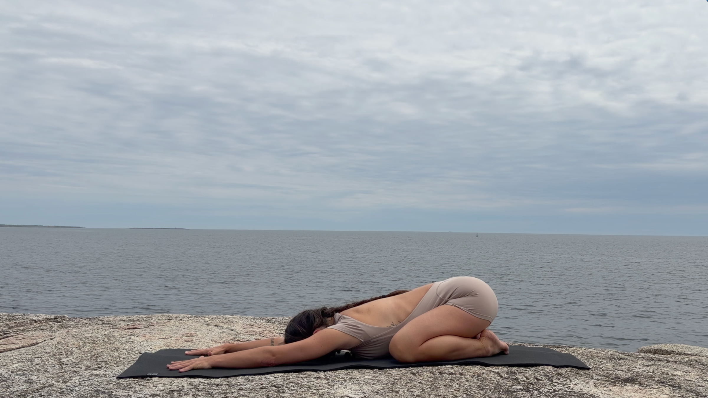 Teacher Emily Baltzer poses in child's pose, part of her daily yoga routine