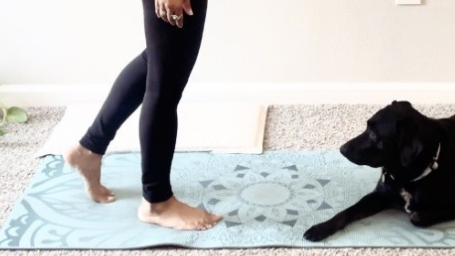 Woman walking on a yoga mat with her right foot planted on the mat and the heel of her left foot lifted