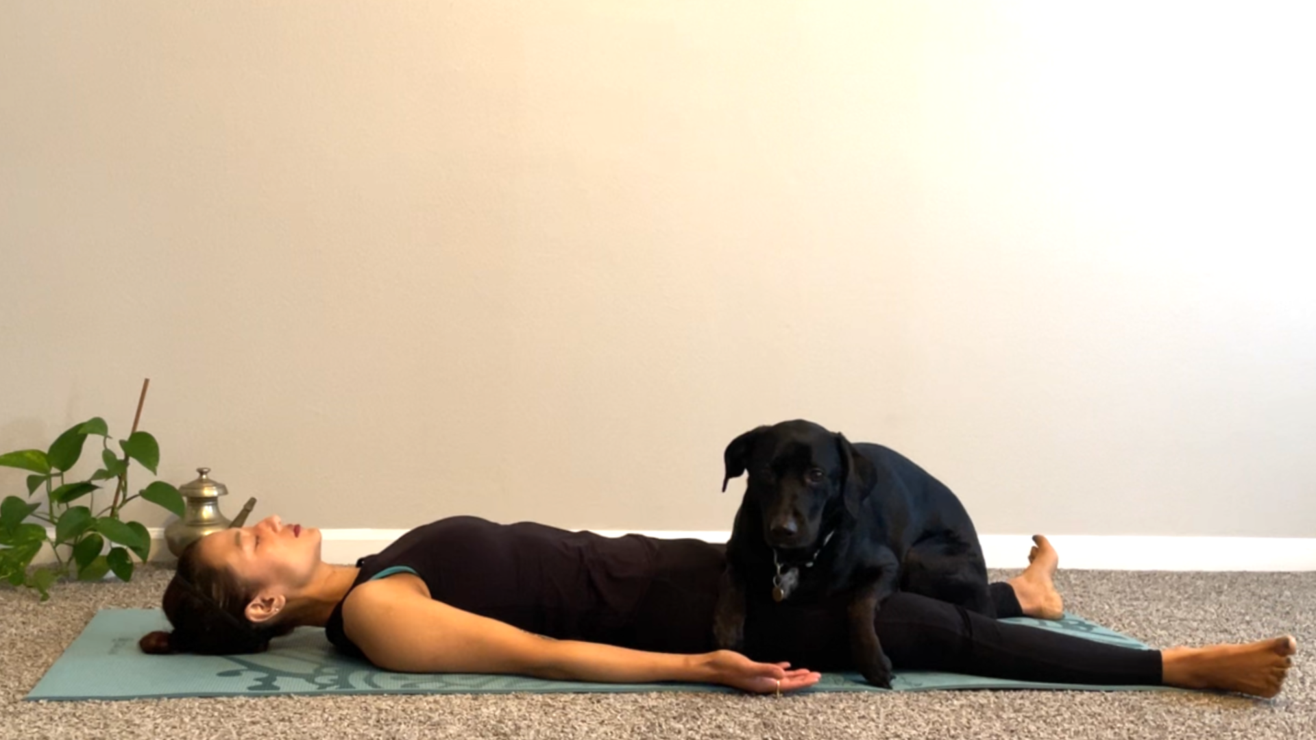 A woman lies on a yoga mat in Savasana to calm her heat rage