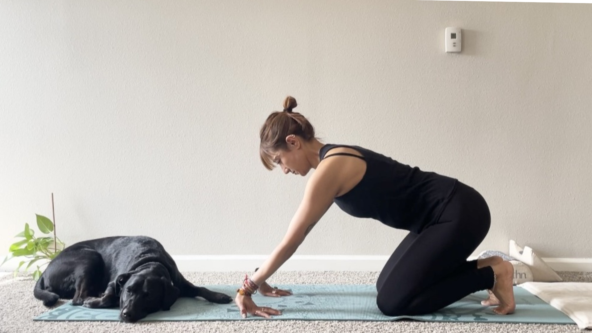 Woman kneeling on a yoga mat and leaning back to stretch the forearm muscles