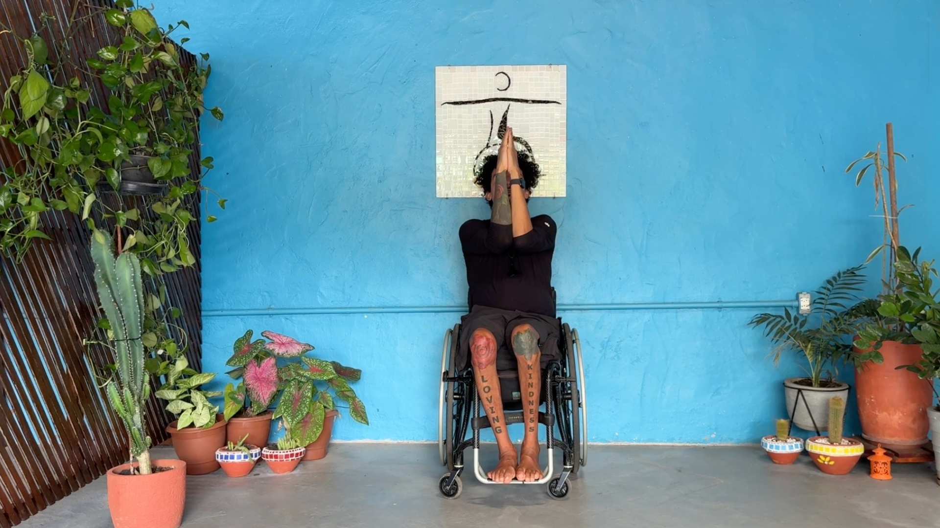 Man sitting in a wheelchair with his arms together in front of his chest