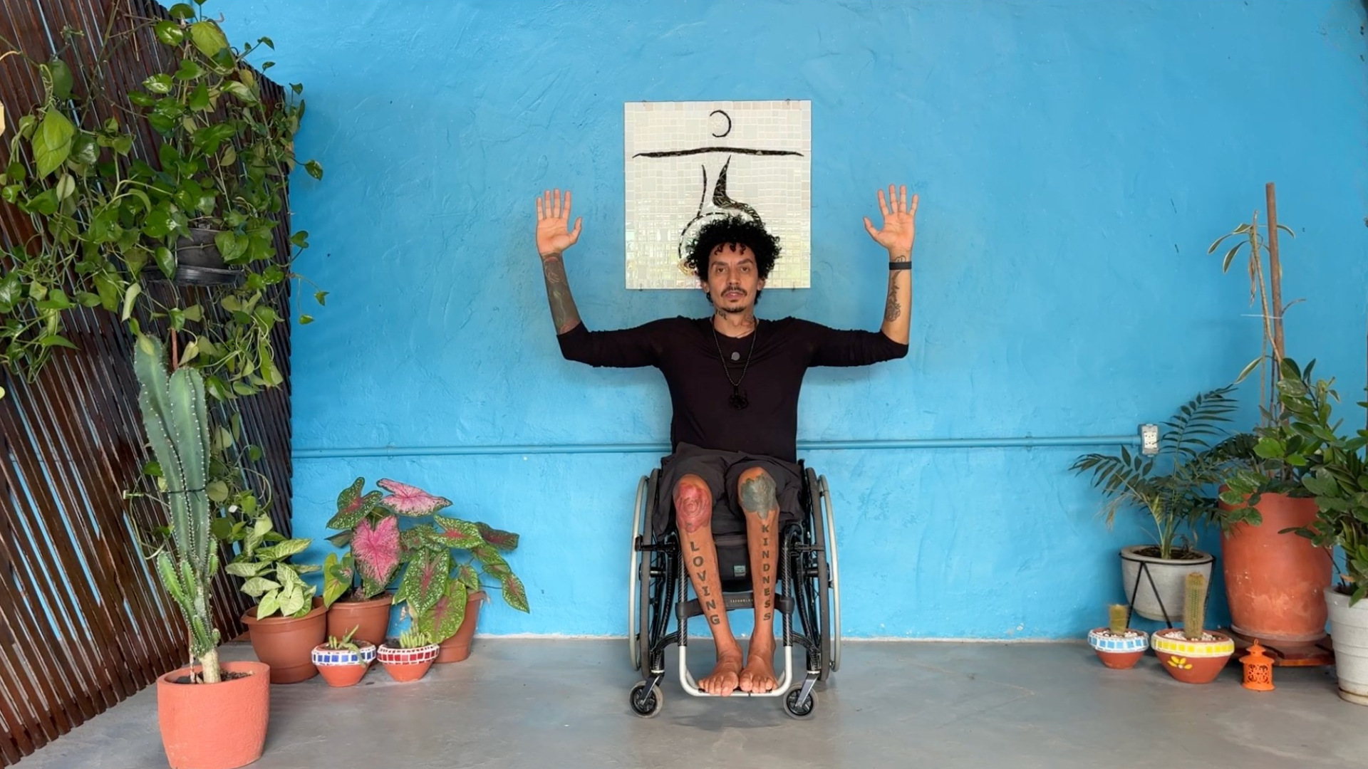 Yoga teacher holding arms out with elbows bent in a cactus form