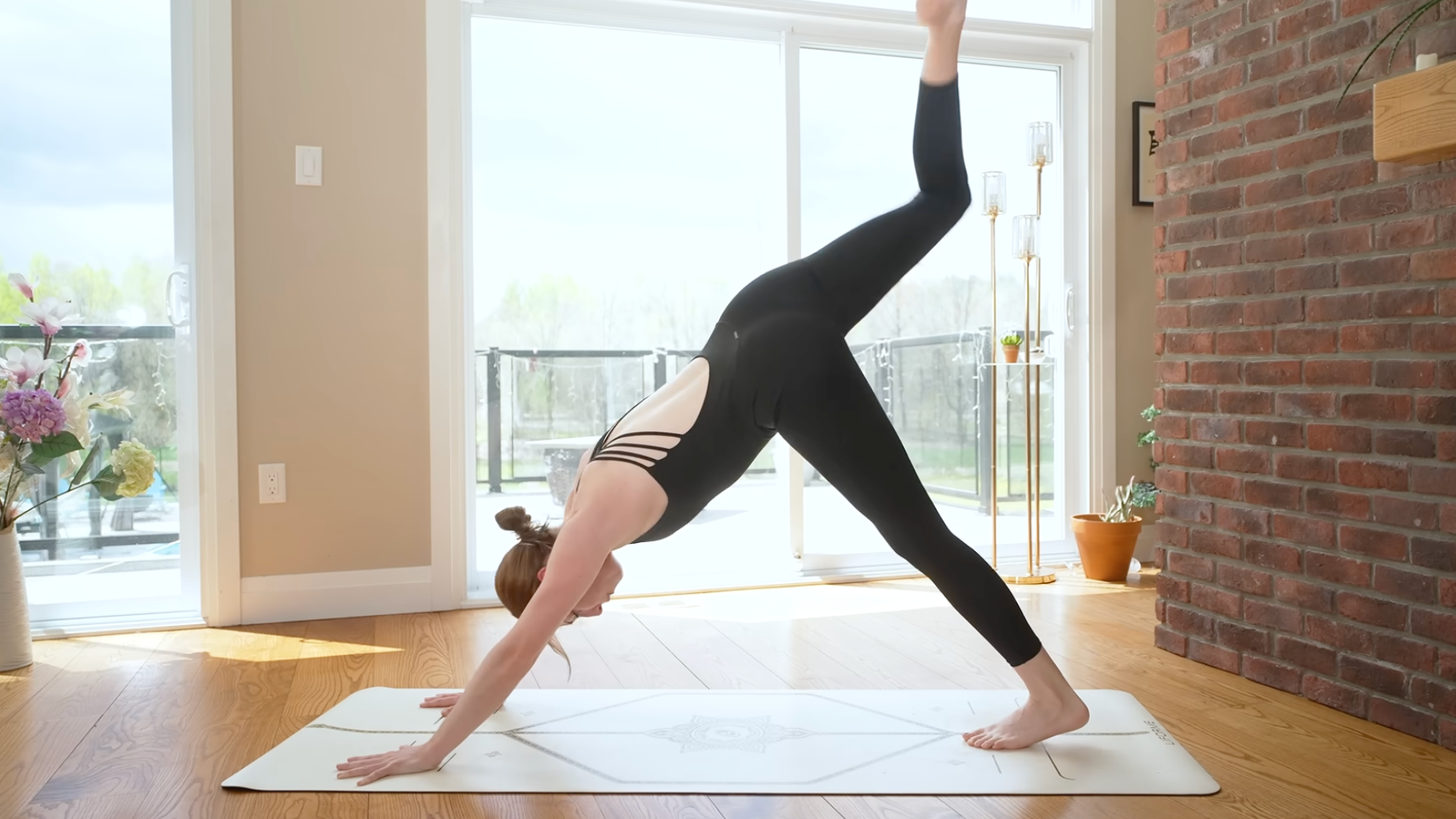 Woman on yoga mat in three-legged dog