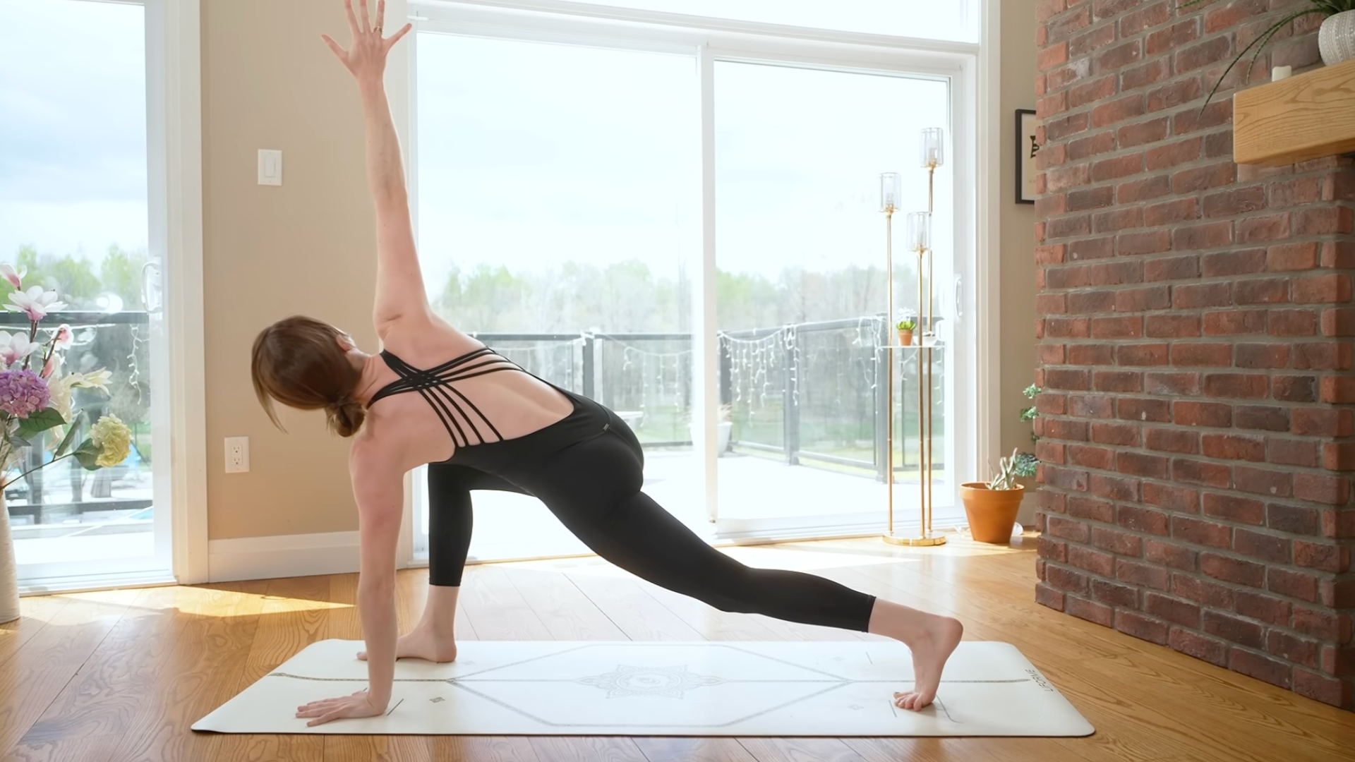 Woman in low lunge twists on mat during yoga wake up class