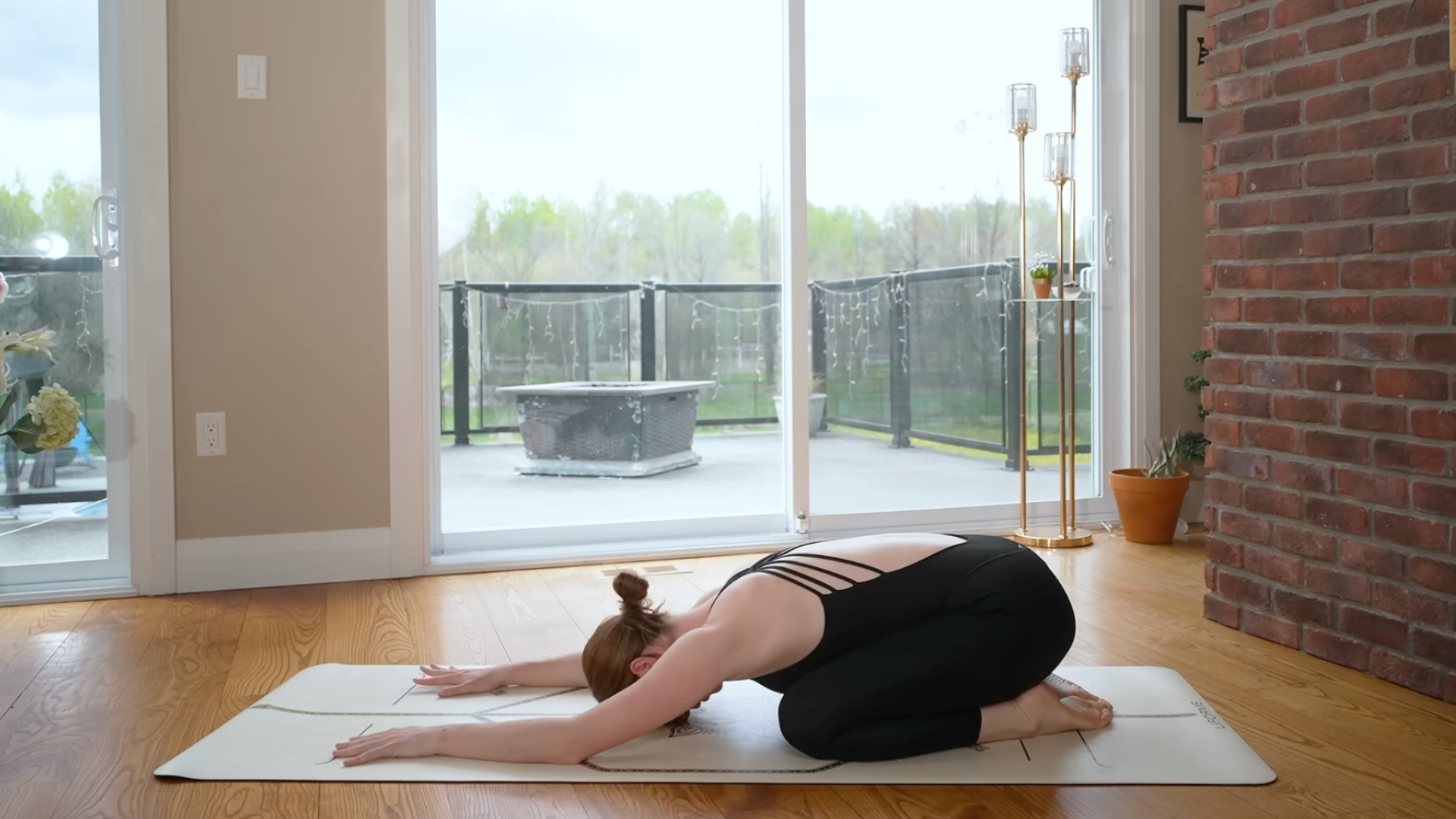 Woman kneeling on a yoga mat in Child's Pose or Balasana