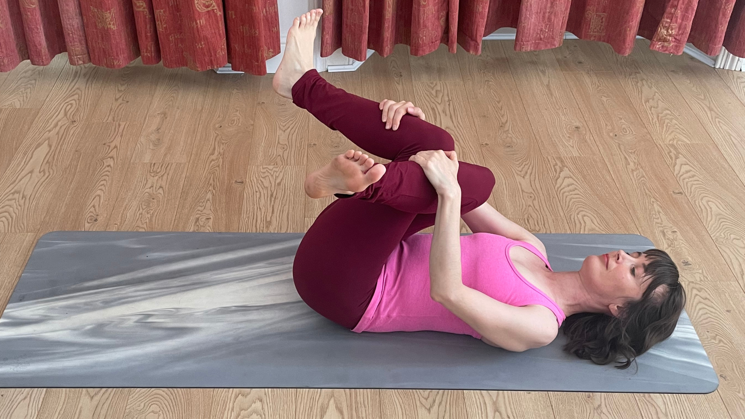 Amber Burke practicing Reclining Cow Face Pose.