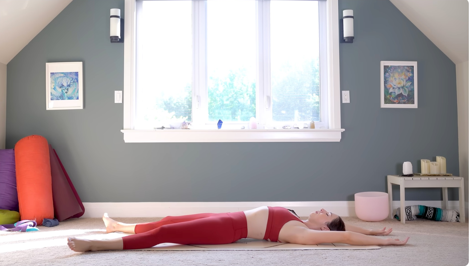 Woman lying on a mat in a version of Savasana with her arms overhead