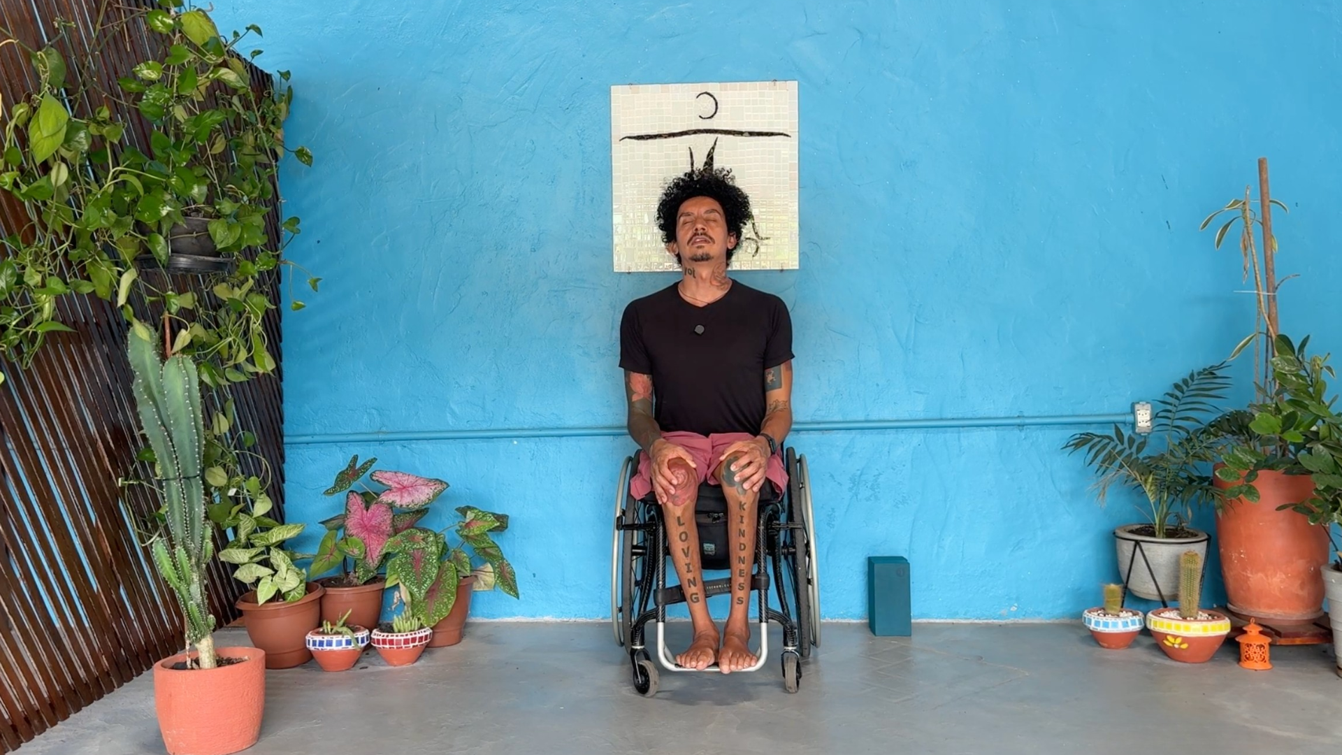 Accessible yoga teacher arching his back demonstrating Cow during a yoga for acceptance class