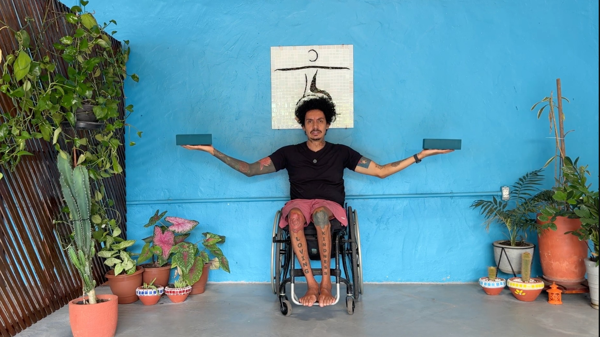 Accessible yoga teacher Rodrigo Souza holding blocks on his hands