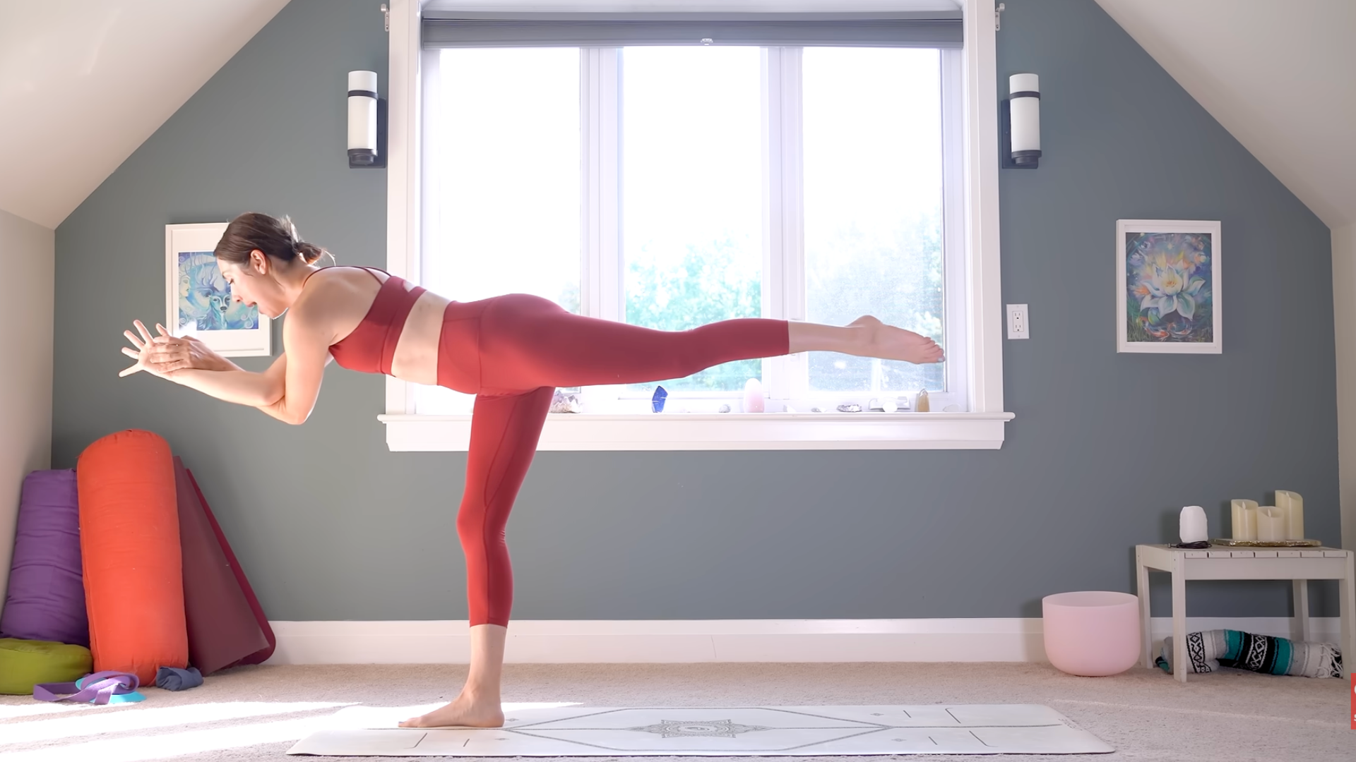 Woman in Warrior 3 or Virabhadrasana III with elbows crossed in Eagle arms