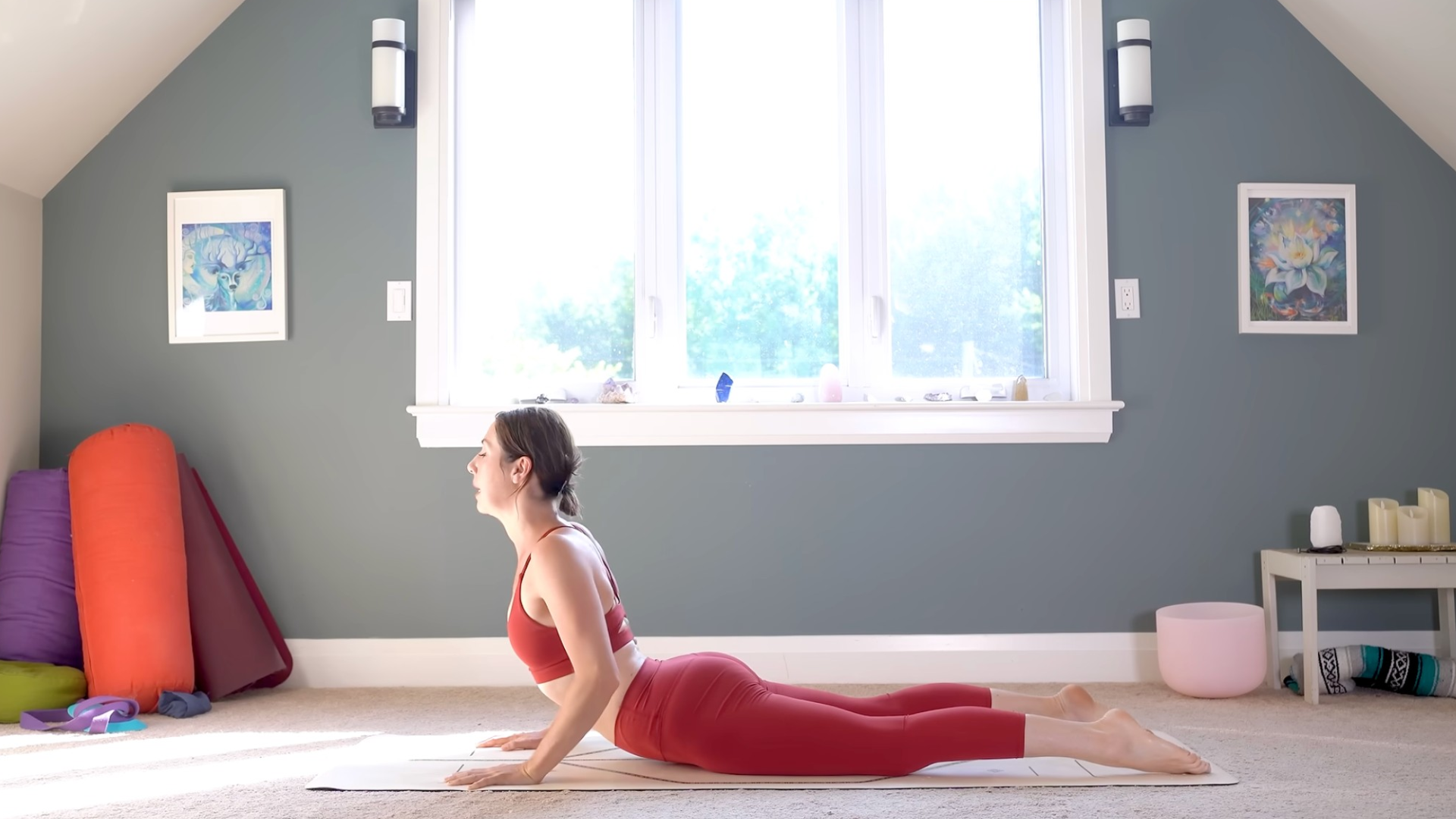 Woman lying on her belly on a yoga mat with her hands on the mat in Cobra 