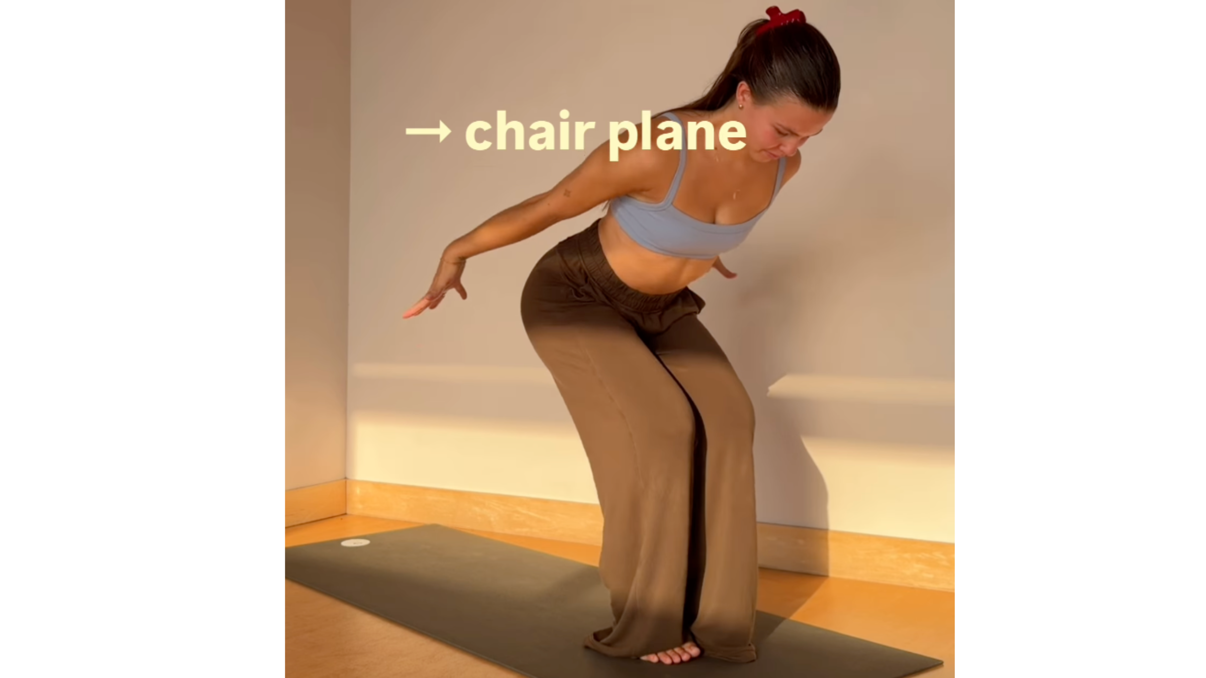 Yoga practitioner in Chair Plane pose with knees bent, hips lowered, chest angled forward, and arms swept back past the hips.