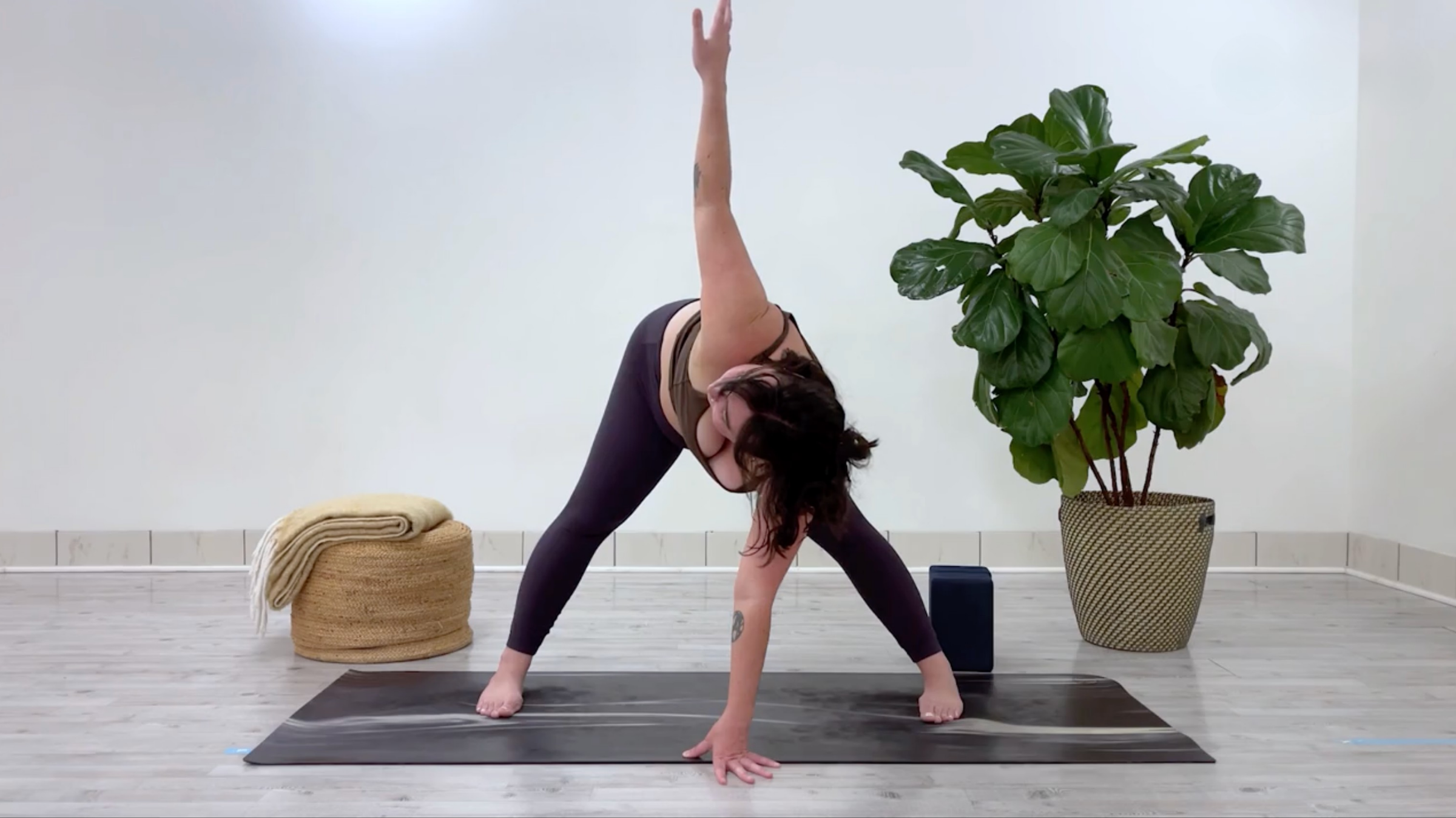 Taylor Lorenz in Revolved Wide-Angled Standing Forward Bend, part of her yoga for stress relief flow for back to school season