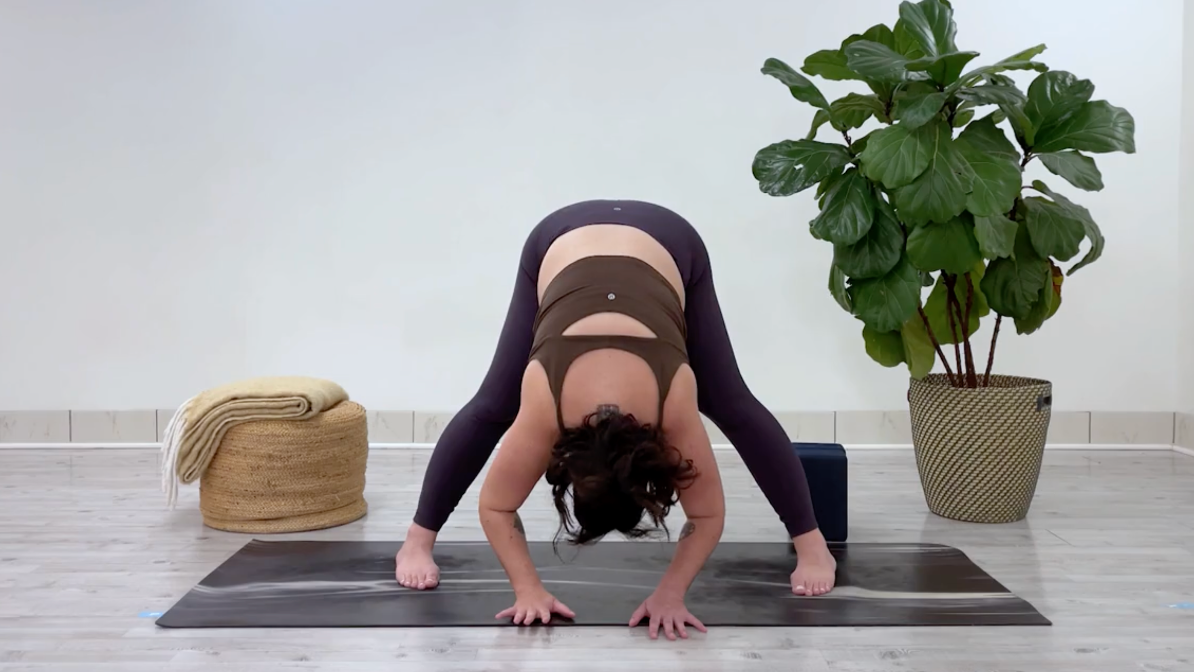 Taylor Lorenz in Wide-Angled Standing Forward Bend, part of her yoga for stress relief flow for back to school season