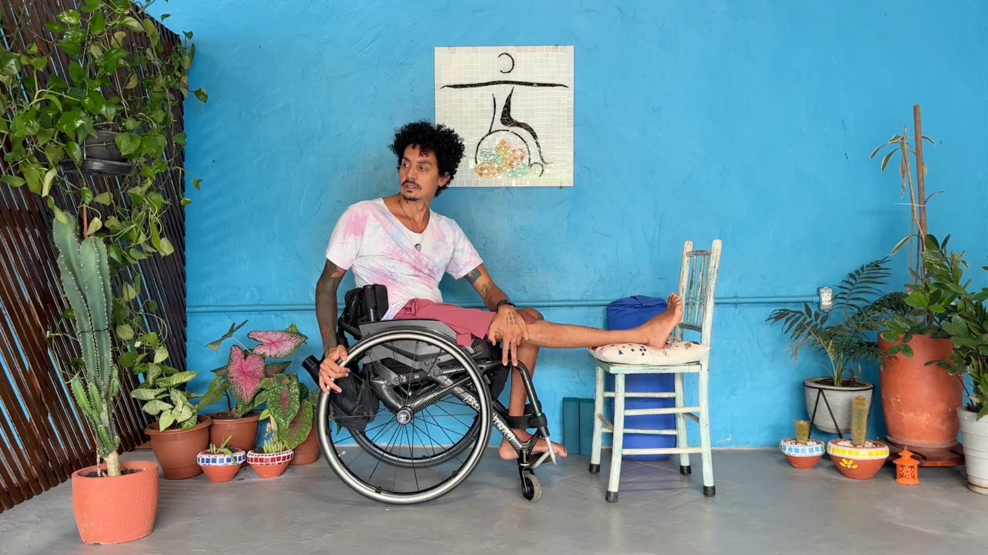 Yoga teacher Rodrigo Souza leading a wheelchair-accessible yoga class and teaching a Seated Twist
