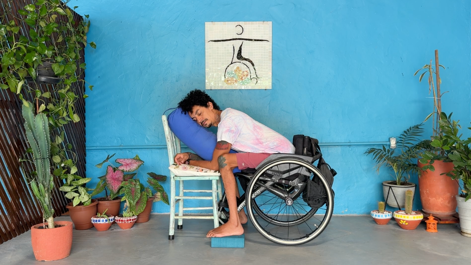 Yoga teacher demonstrating a supported childs pose or balasana pose by leaning forward onto a bolster