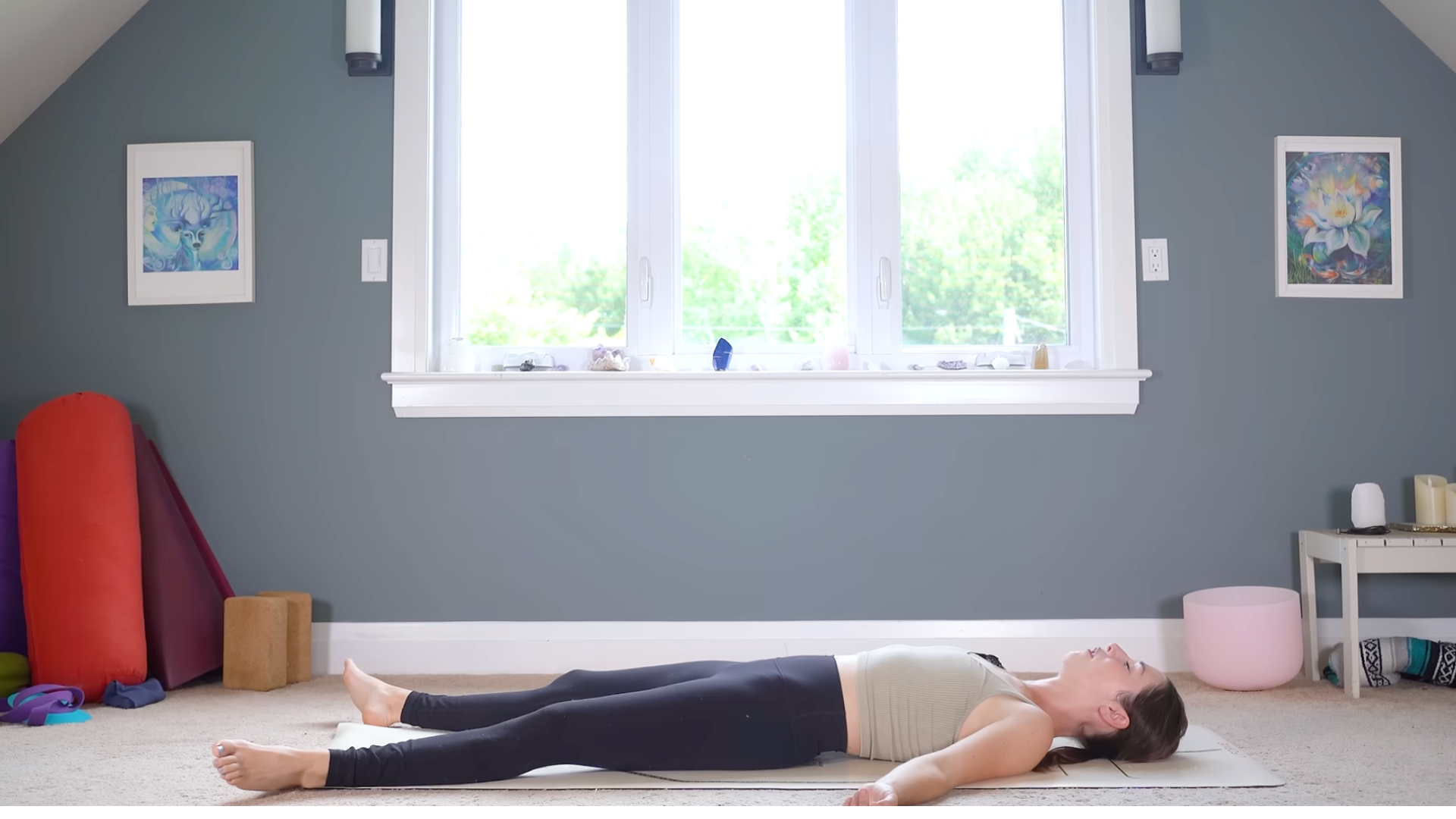 Yoga With Kassandra lying on a yoga mat in Savasana
