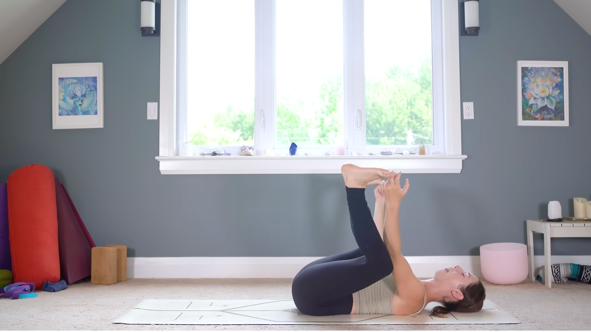 Woman lying on her back in Happy Baby pose or Ananda Balasana