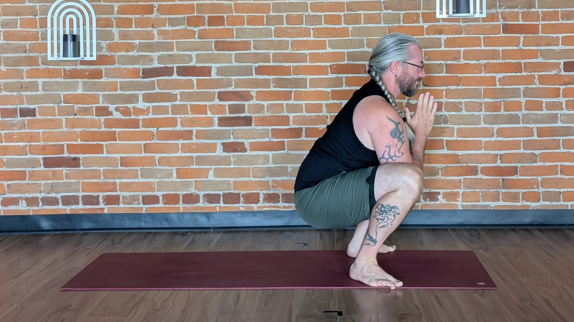 Yoga teacher Jared McKenzie in a yogi squat or Malasana with his feet and knees angled outward