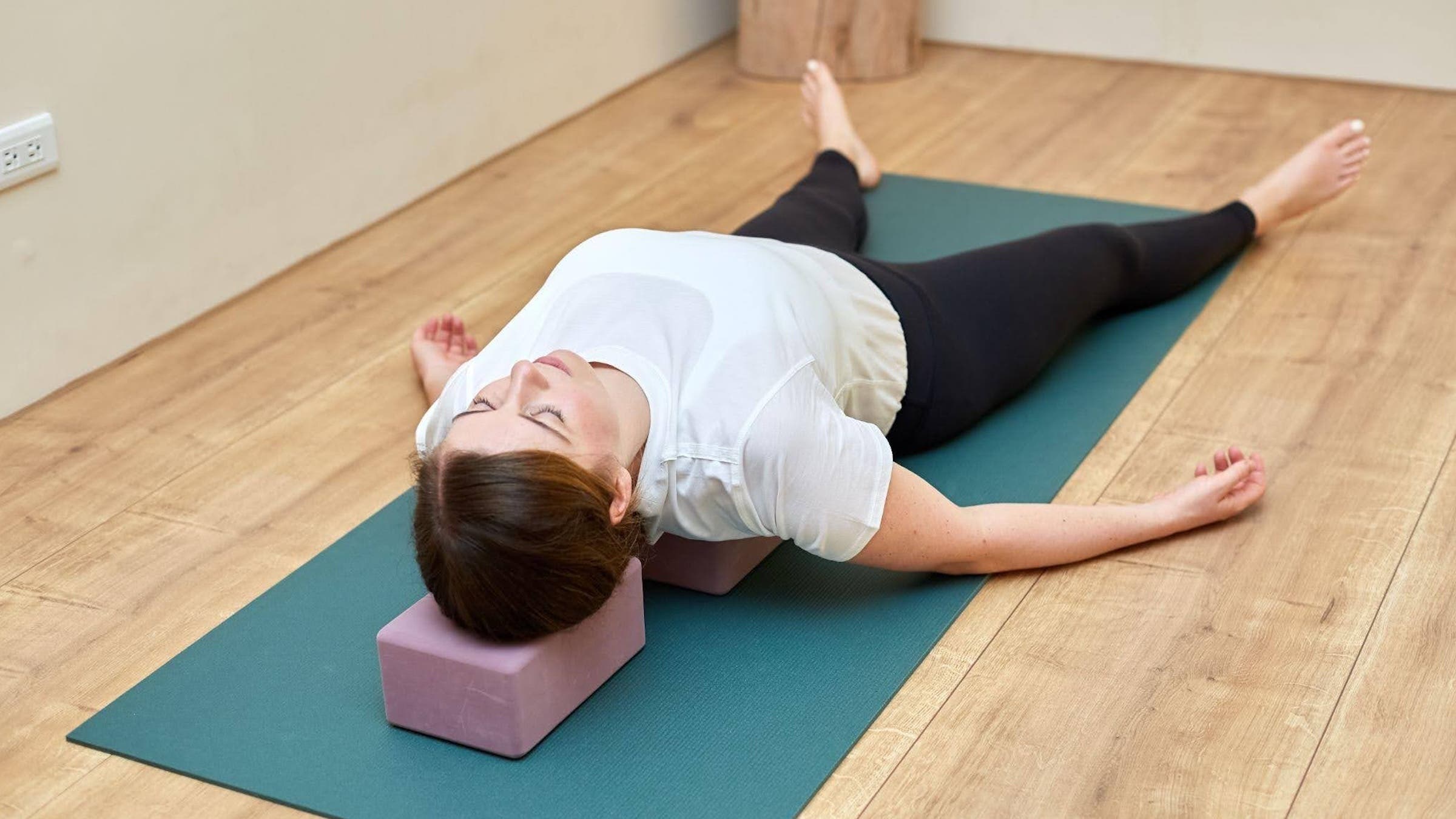 A woman in Supported Fish Pose