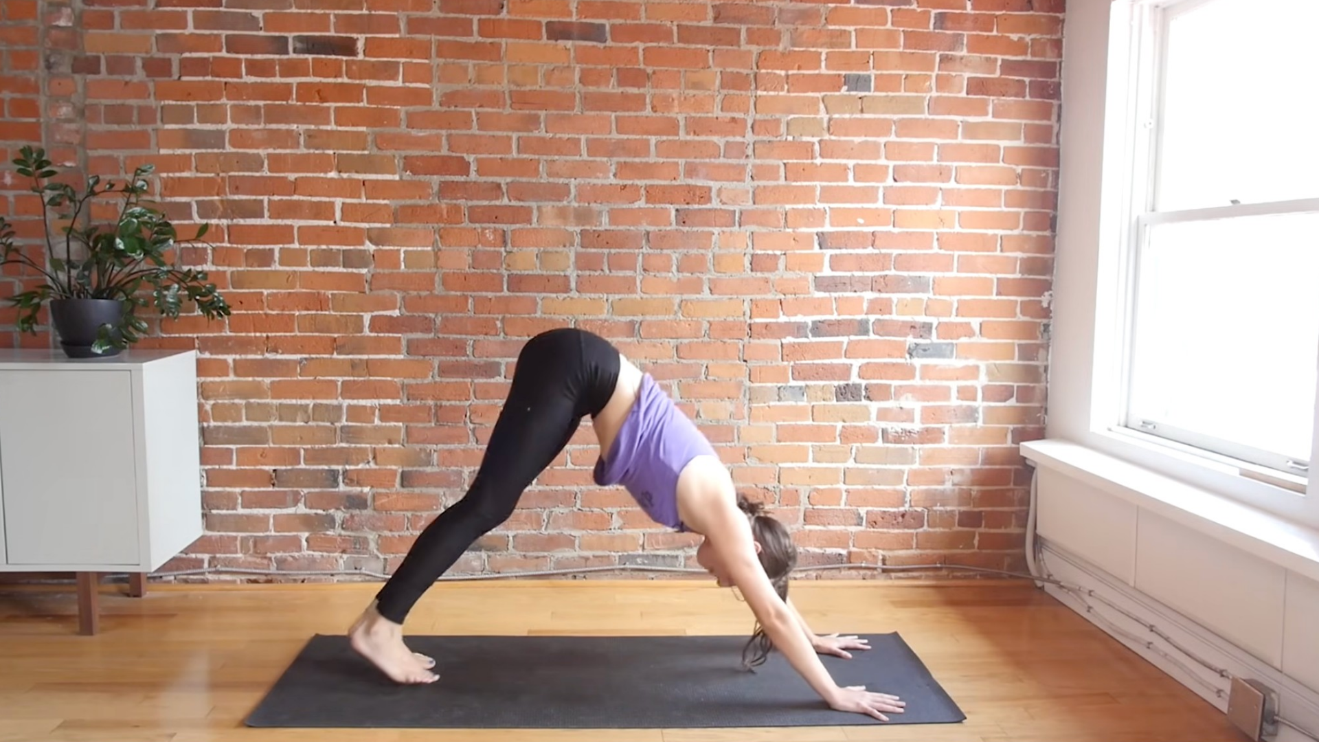 Woman practicing Downward-Facing Dog or Adho Mukha Svanasana