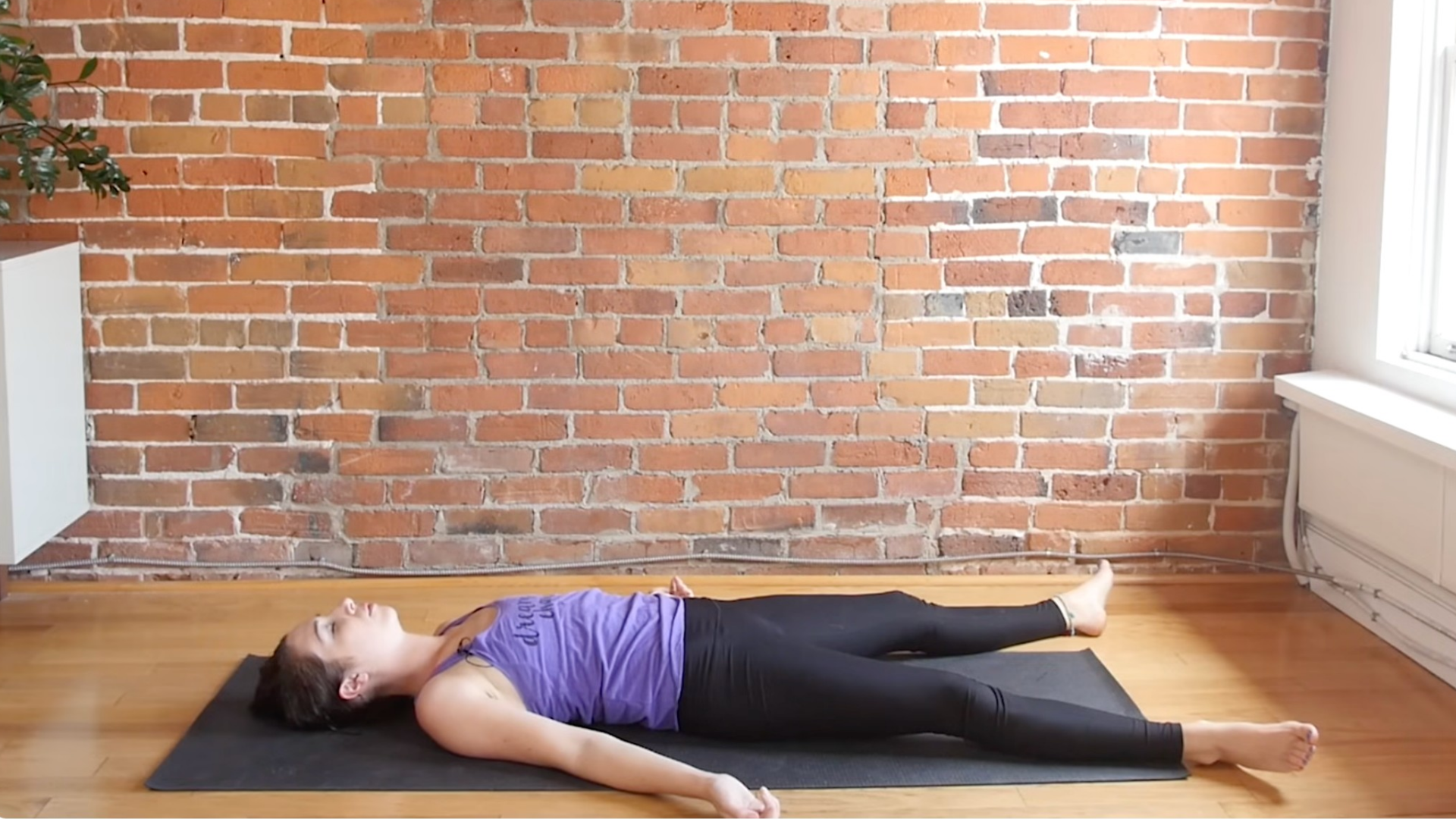 Woman in Savasana after a yoga balance sequence