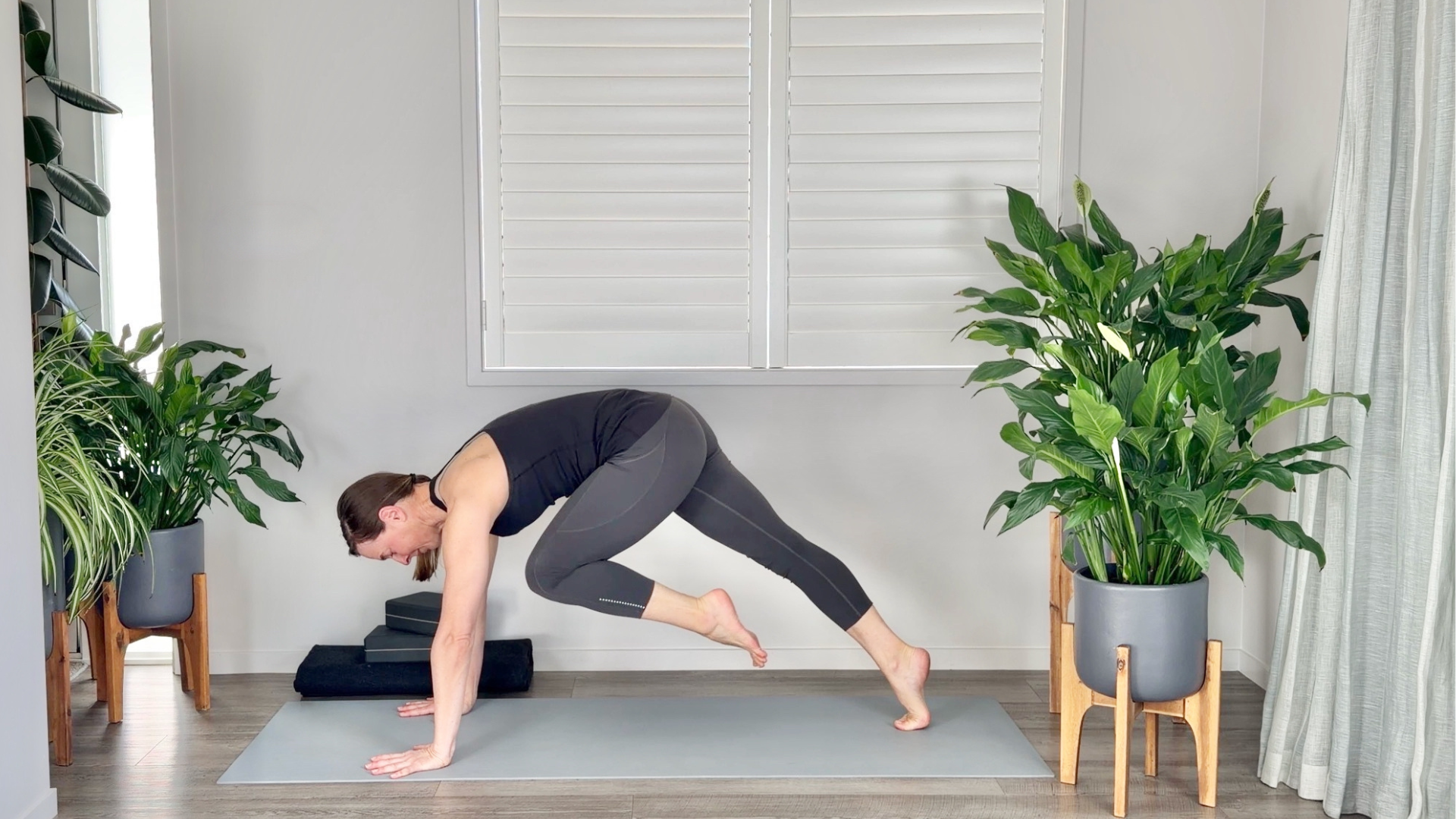 Woman moving her knee toward her elbow in a transition during a yoga for core strength practice 