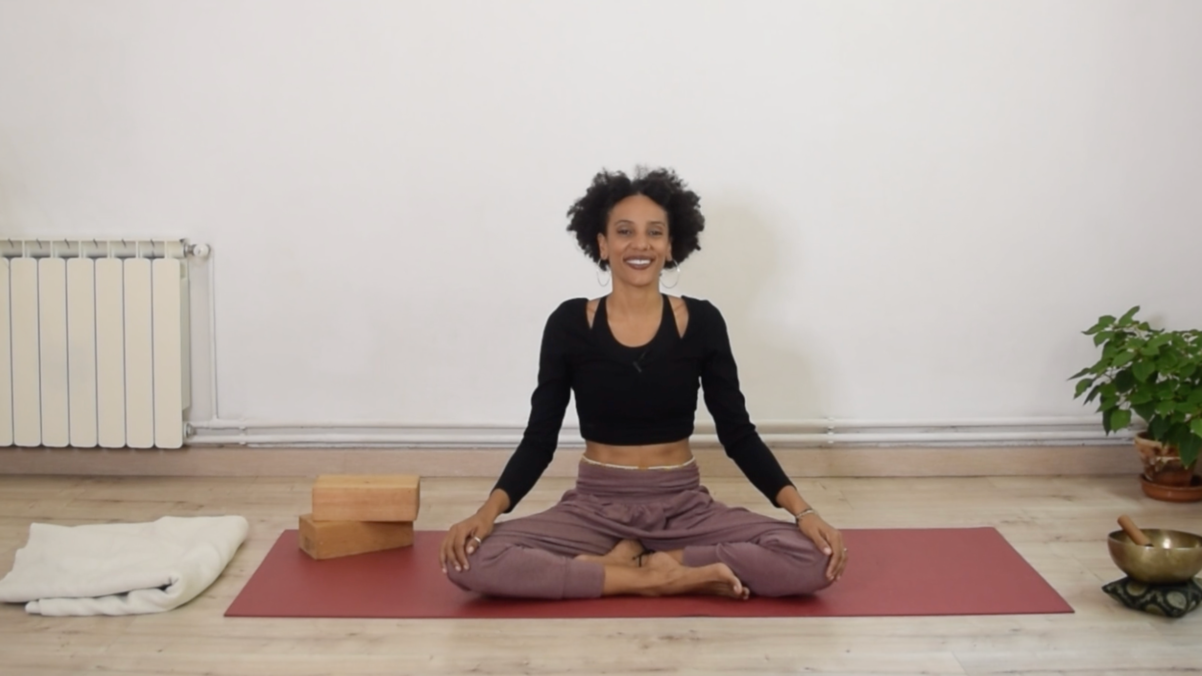 Yoga instructor Laia Bové sitting cross-legged on a yoga mat in Easy Pose with a relaxed posture.