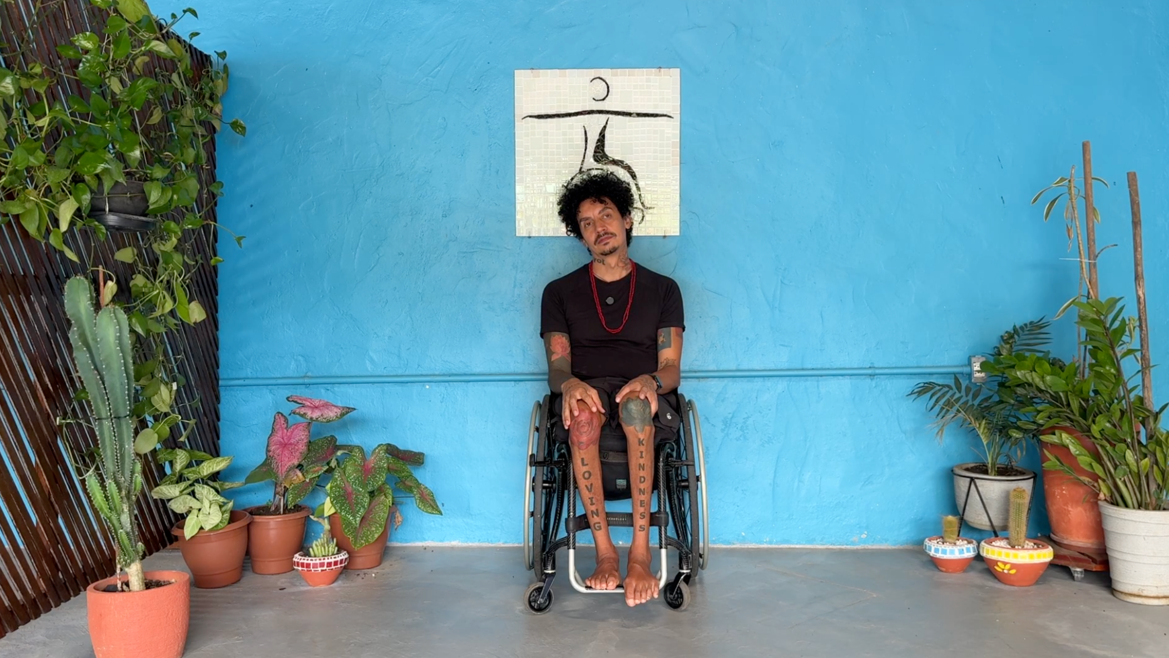 man in wheelchair in Neck Stretch pose with hands resting on knees and head tilted toward right shoulder