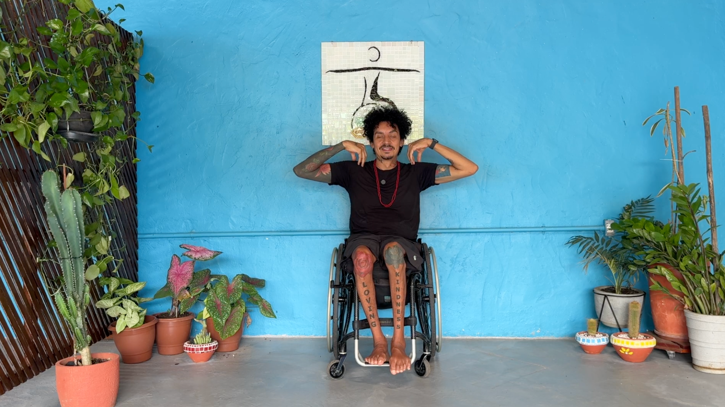 man in wheelchair in Shoulder Rolls with arms bent, shoulders raised to the height of the shoulders, and fingertips resting on top of shoulders