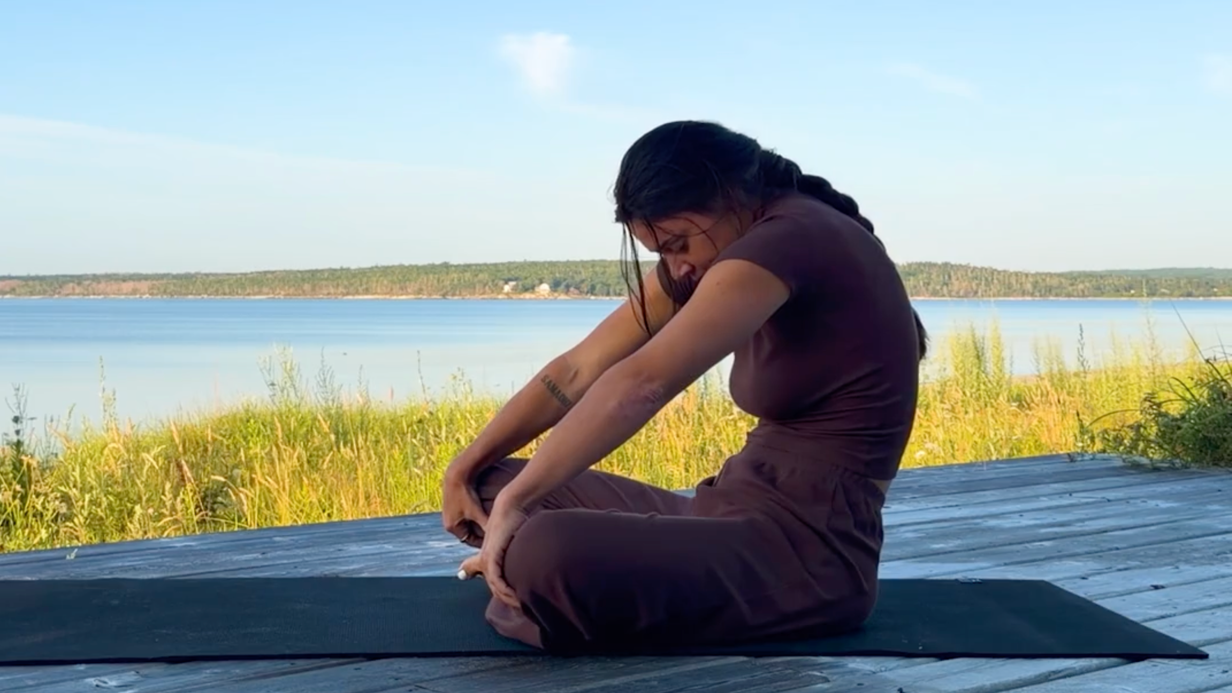 Yoga teacher Emily Baltzer in Seated Cat Pose, one of her seated yoga poses