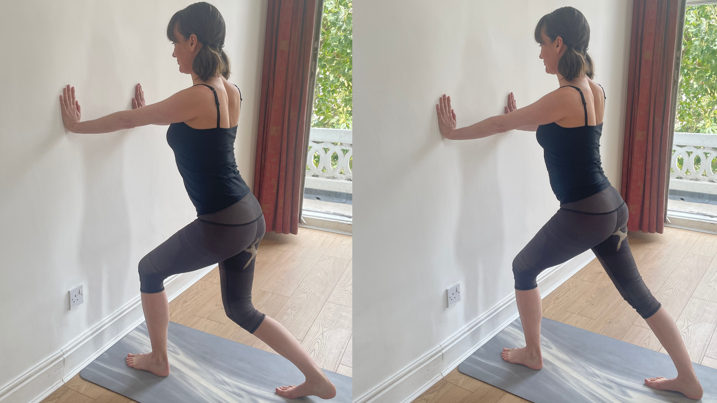 Amber Burke standing and facing a wall with her hands pressed against it at shoulder height, her right leg stepped back and straight, pressing the heel down toward the mat.