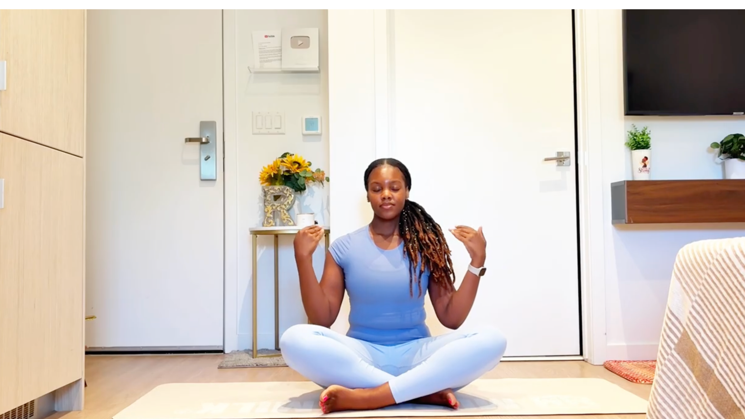 Ramoni Overton sitting on yoga mat practicing hand circles.