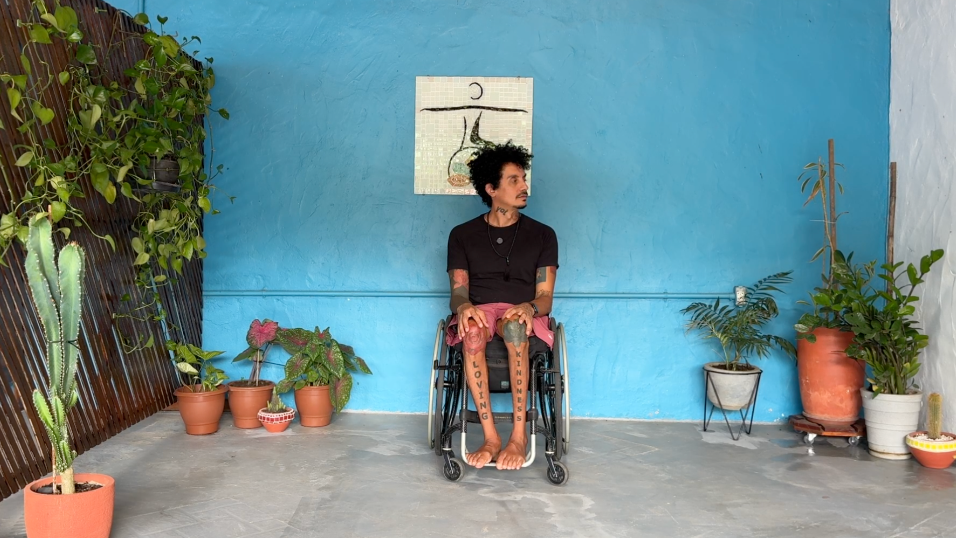 Yoga teacher leading a neck stretch from a wheelchair yoga class by turning his head toward the right