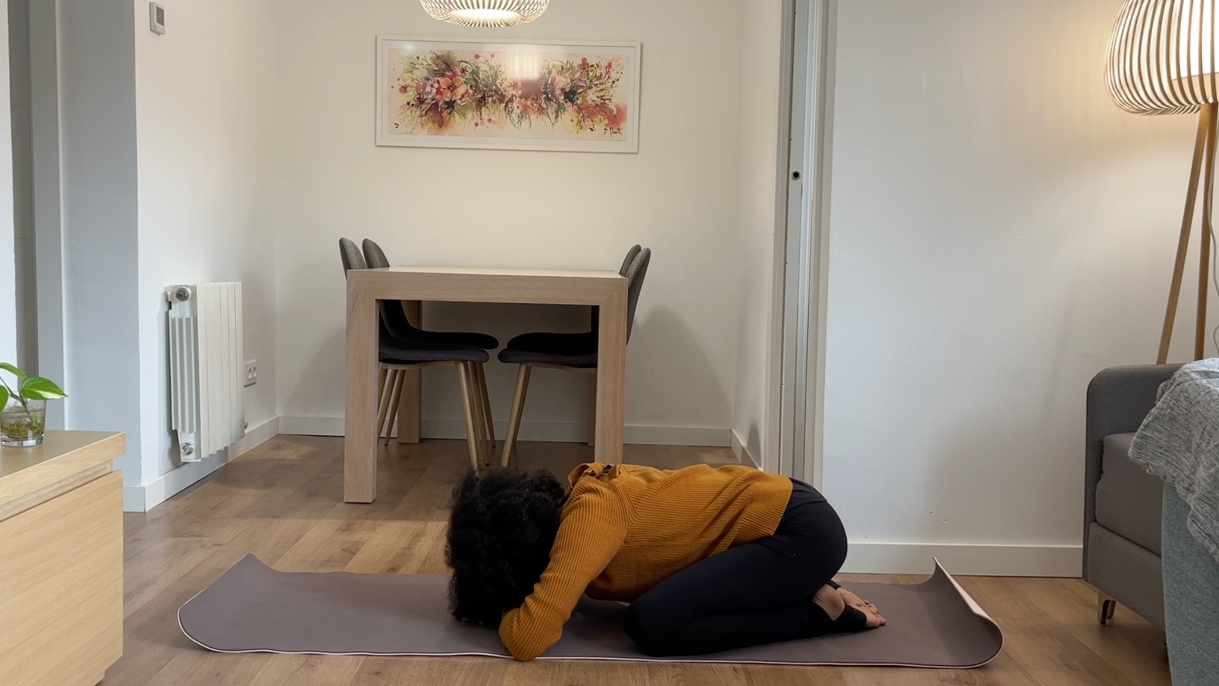 Laia Bové resting in Child's Pose with hips lowered toward her heels and forehead resting gently on stacked forearms.