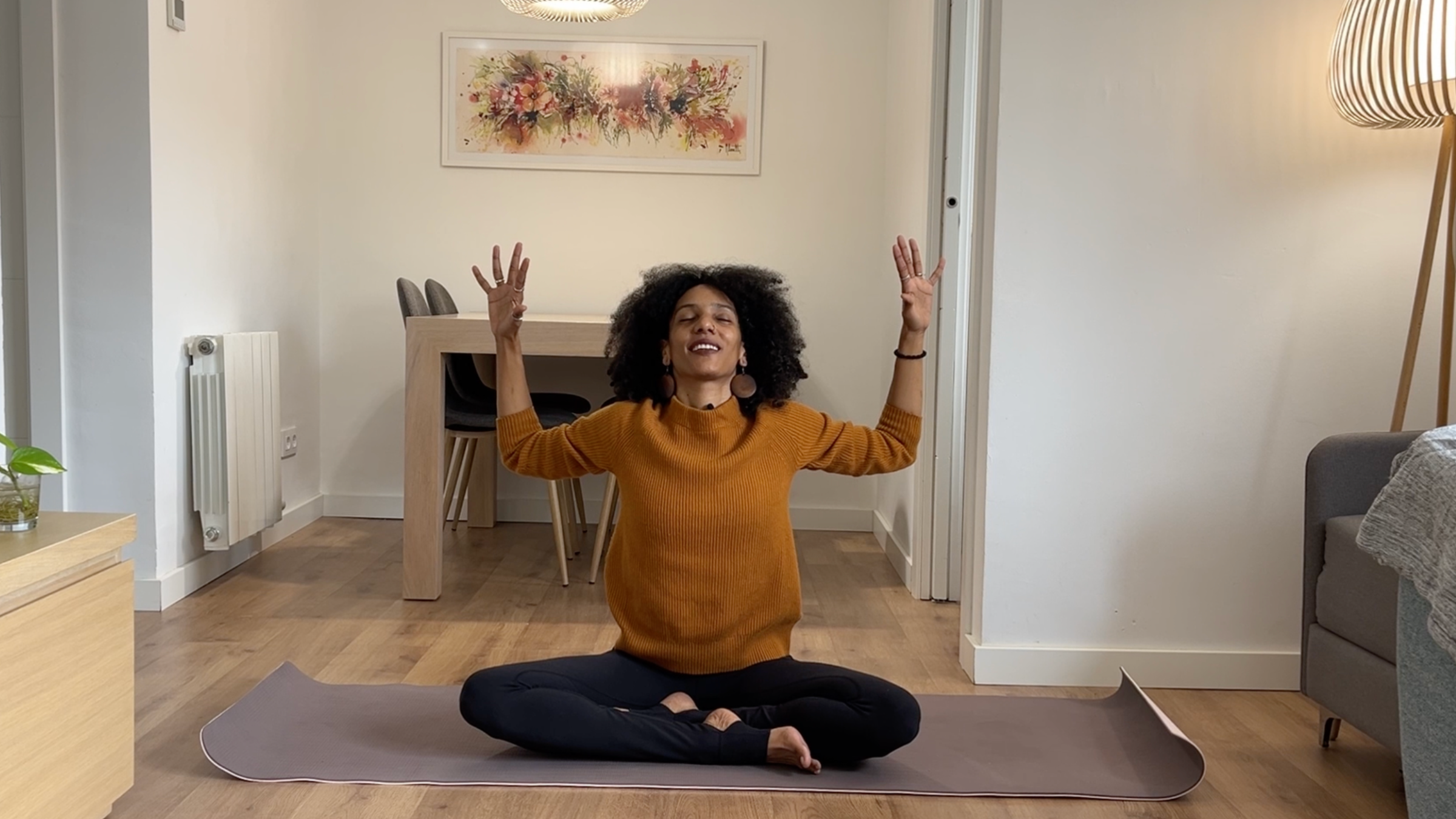Laia Bové demonstrating seated Cat-Cow with cactus arms, alternating between lifting the chest and rounding the spine.