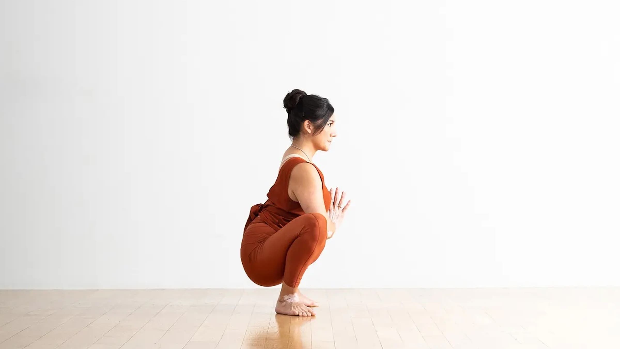 A woman in Garland Squat, Malasana in Sanskrit