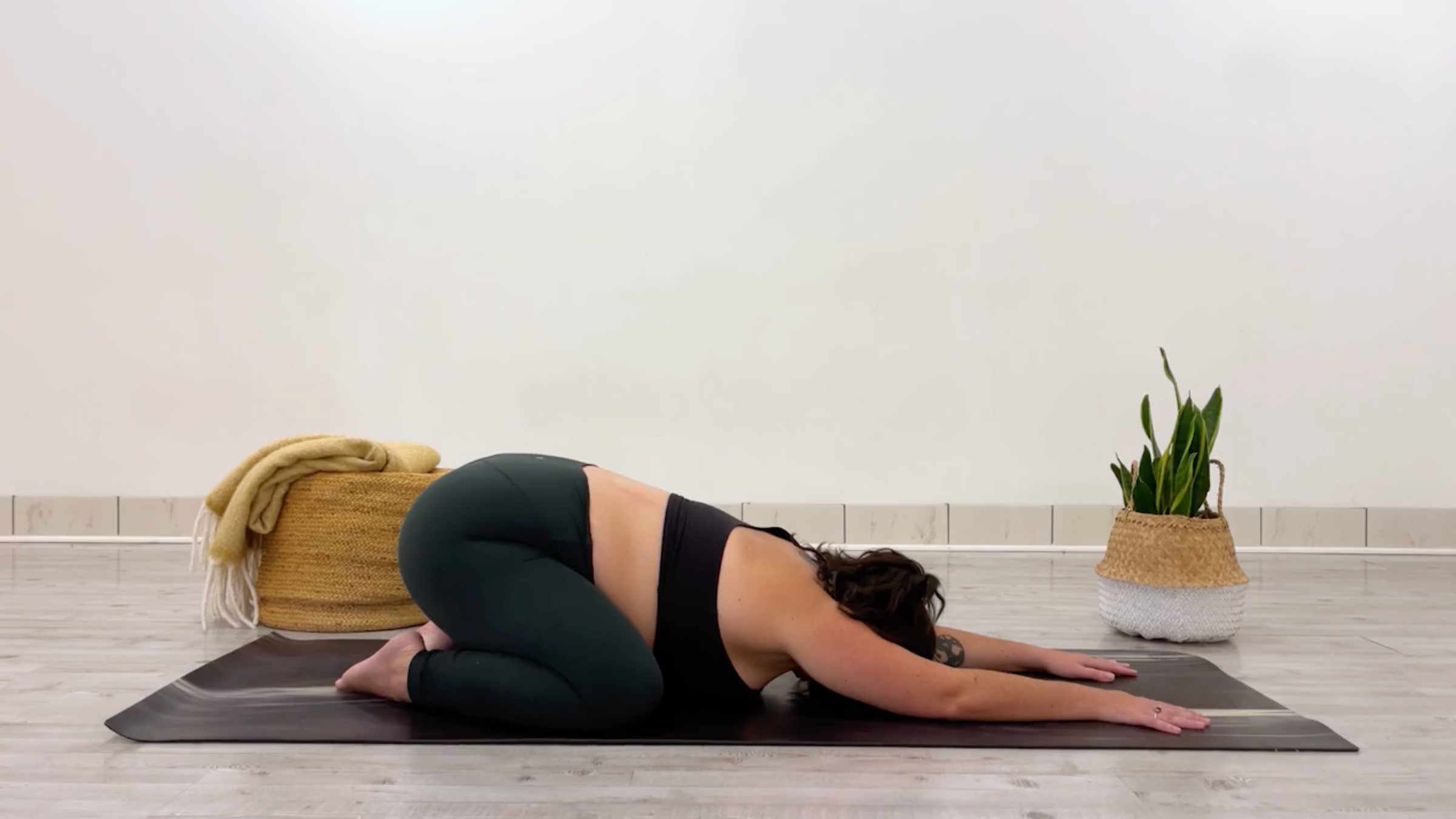 Yoga teacher Taylor Lorenz in Child's Pose, Balasana in Sanskrit, part of her series of glute stretches