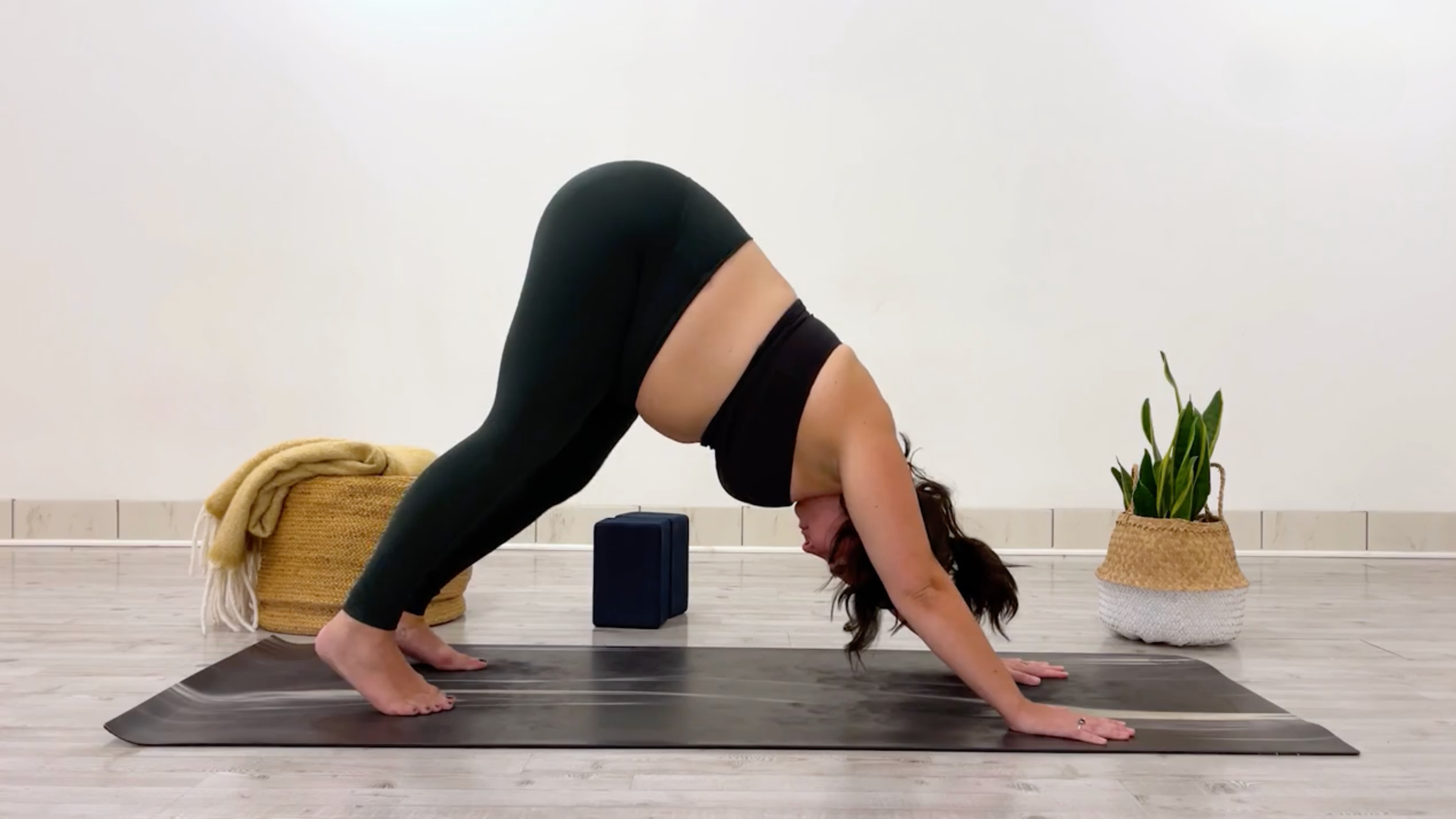 Yoga teacher Taylor Lorenz in Downward-Facing Dog, Adho Mukha Svanasana in Sanskrit, part of her series of glute stretches