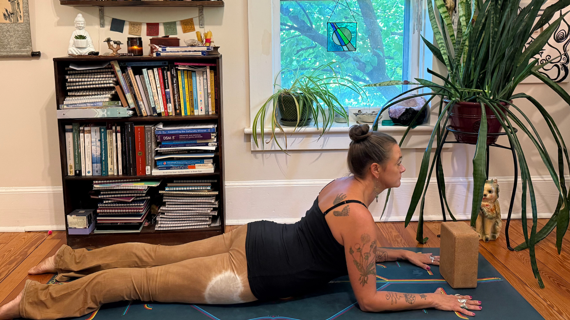 Woman lying on her belly with her forearms on the mat and her chest lifted in Sphinx Pose