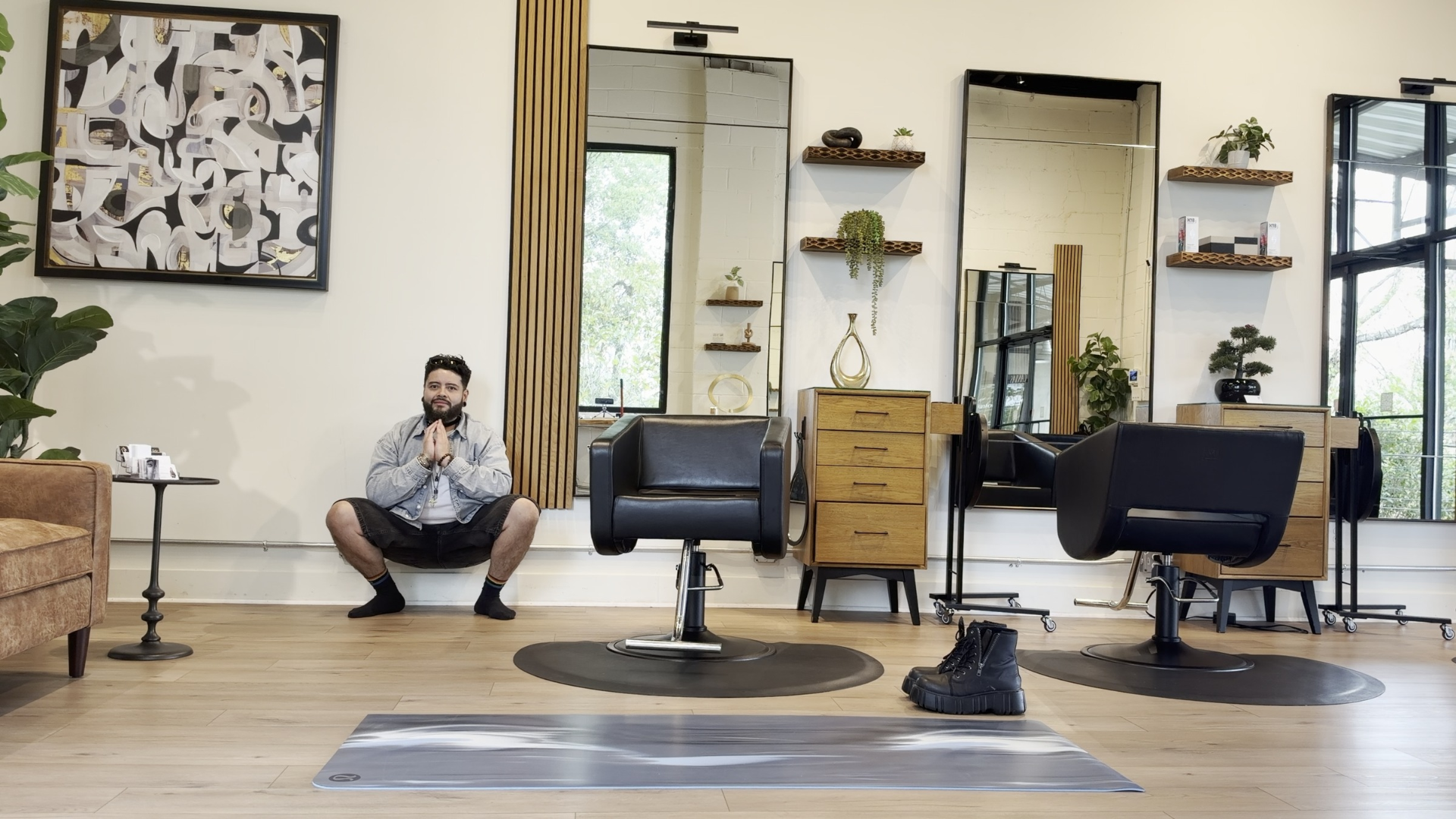 Yoga teacher leaning his back against a wall during a yogi squat or Malasana