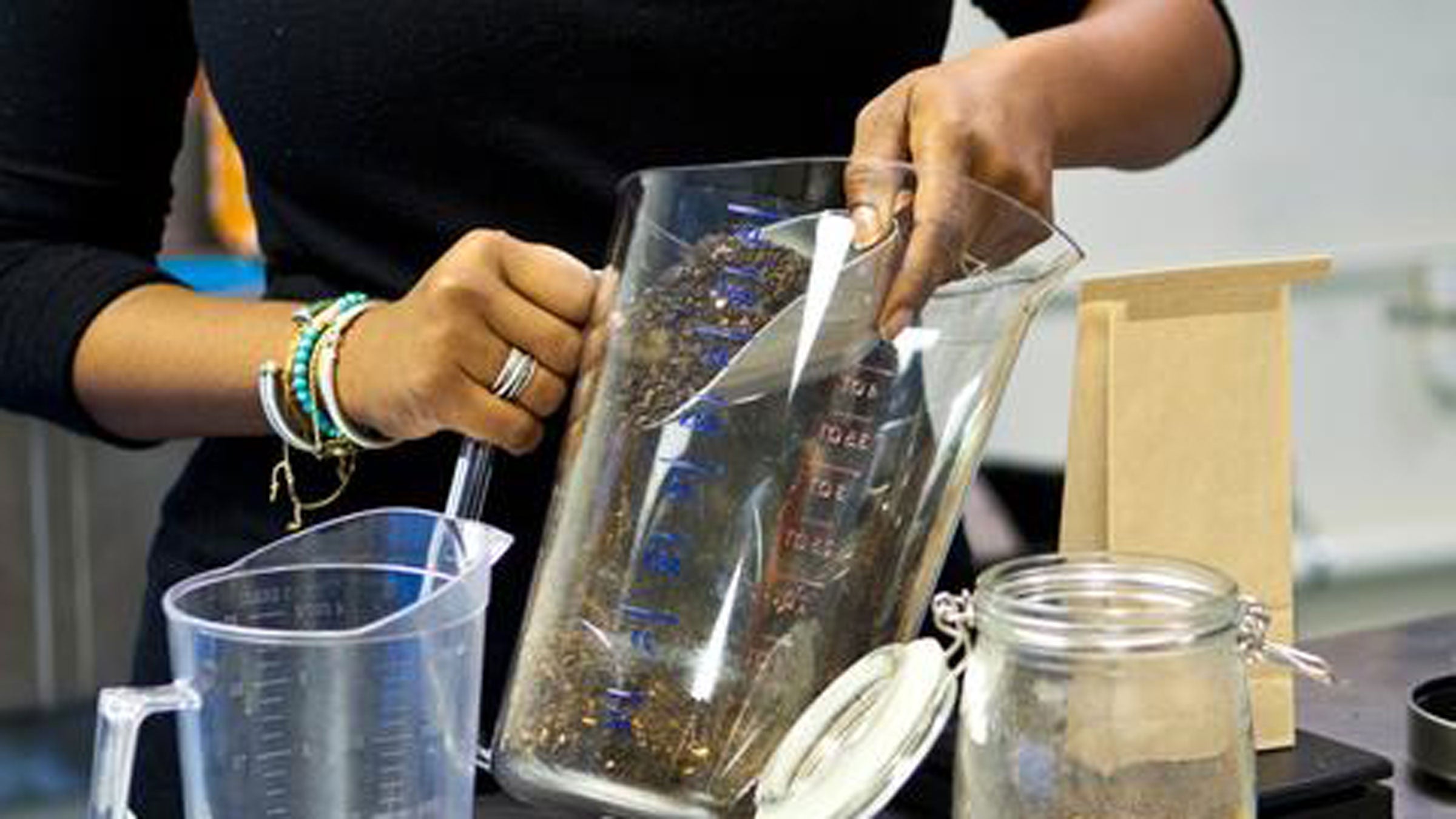 Scooping loose-leaf tea from a clear container